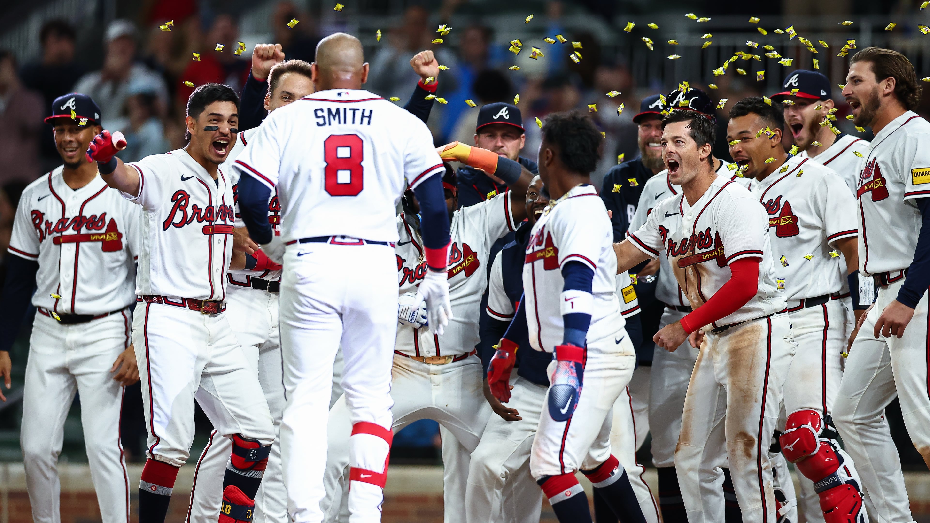 Atlanta Braves' Dominic Smith (8) celebrates with teammates at home plate after hitting a walkoff grand slam in the ninth inning of a baseball game against the Kansas City Royals, Saturday, March 28, 2026, in Atlanta. (AP Photo/Colin Hubbard)