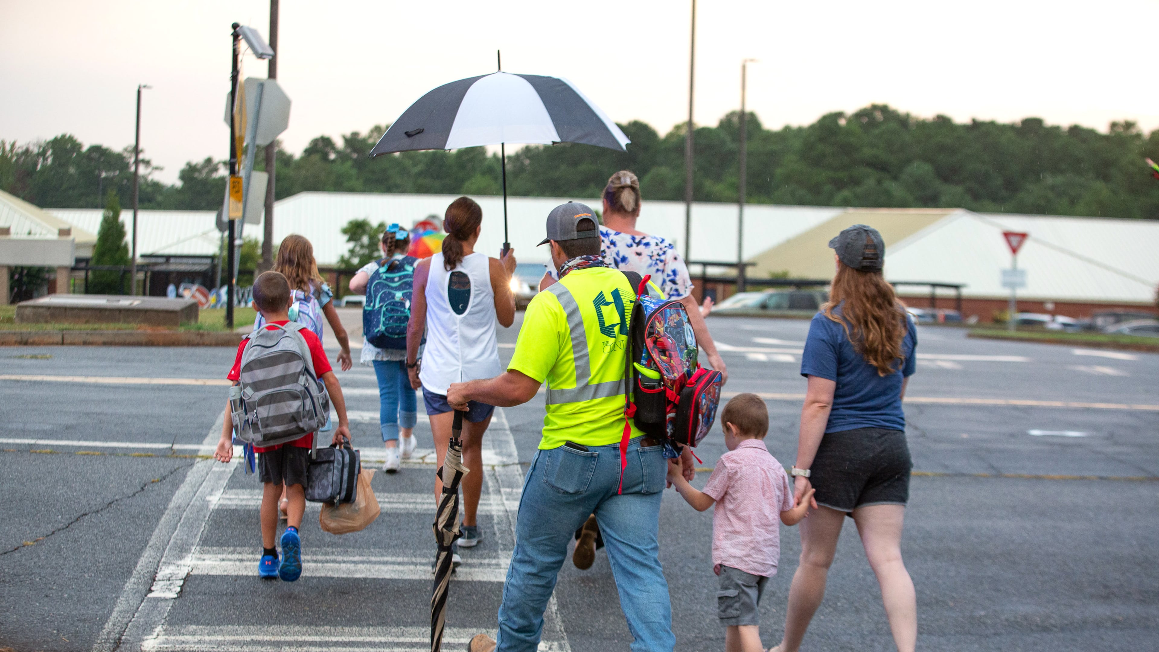 Parents walk their children to the entrance of Woodstock Elementary School in Cherokee County on the first day of school on August 3, 2020. STEVE SCHAEFER FOR THE ATLANTA JOURNAL-CONSTITUTION