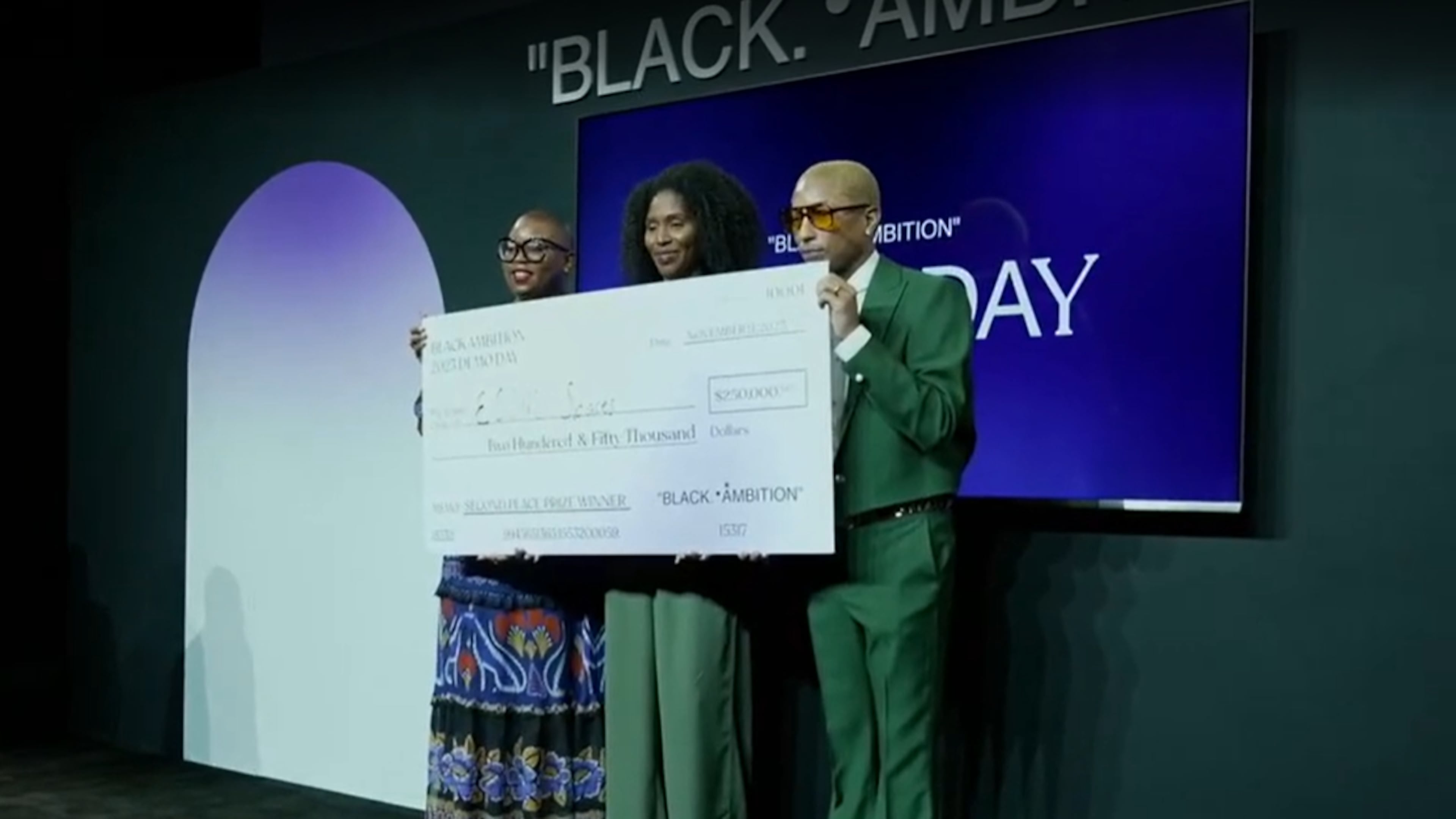 Maïré Bavarday-Rosa (center), co-founder and CEO of Atlanta-based logistics hub ECOMSPACES, stands with Felecia Hatcher (left), CEO of Black Ambition, and Pharrell Williams (right) after winning $250,000 at the Black Ambition Demo Day on Thursday, Nov. 9, 2023.