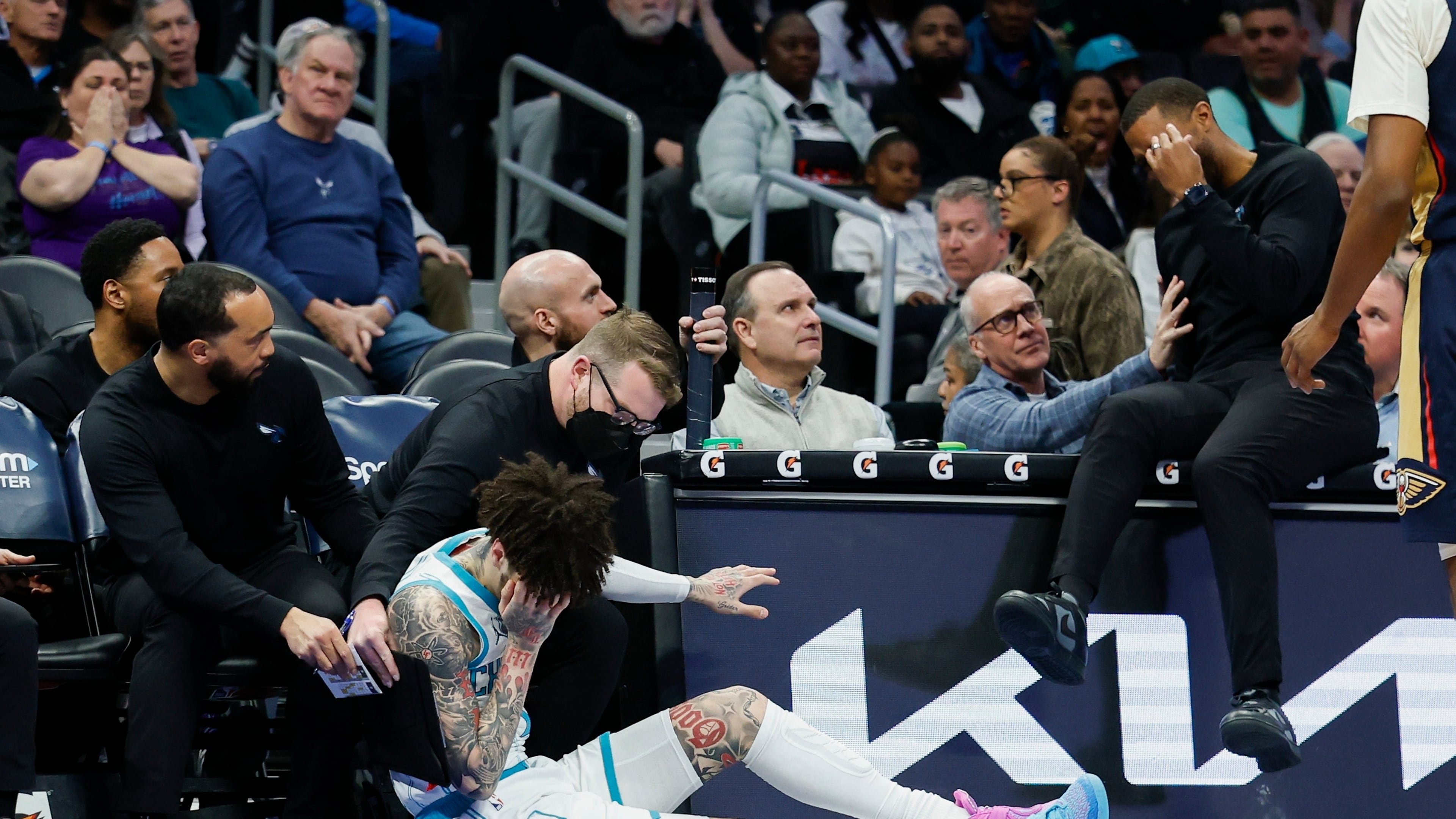 Charlotte Hornets guard LaMelo Ball holds his head after colliding with head coach Charles Lee during the first half of an NBA basketball game against the New Orleans Pelicans, in Charlotte, N.C., Monday, Feb. 2, 2026. (AP Photo/Nell Redmond)