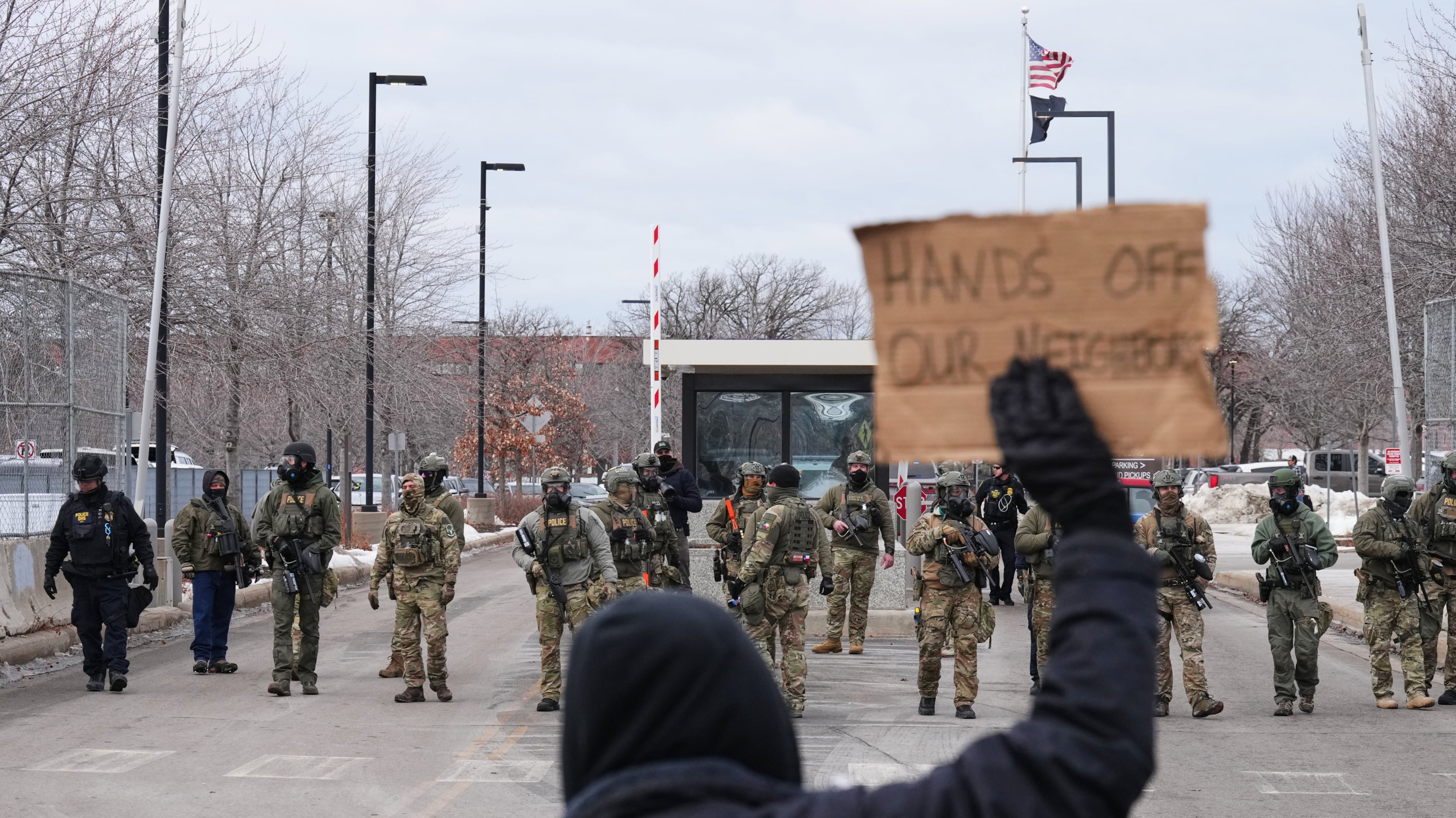 Protesters confront federal immigration officers outside the Bishop Henry Whipple Federal Building, Tuesday, Jan. 13, 2026, in Minneapolis. (AP Photo/Adam Gray)