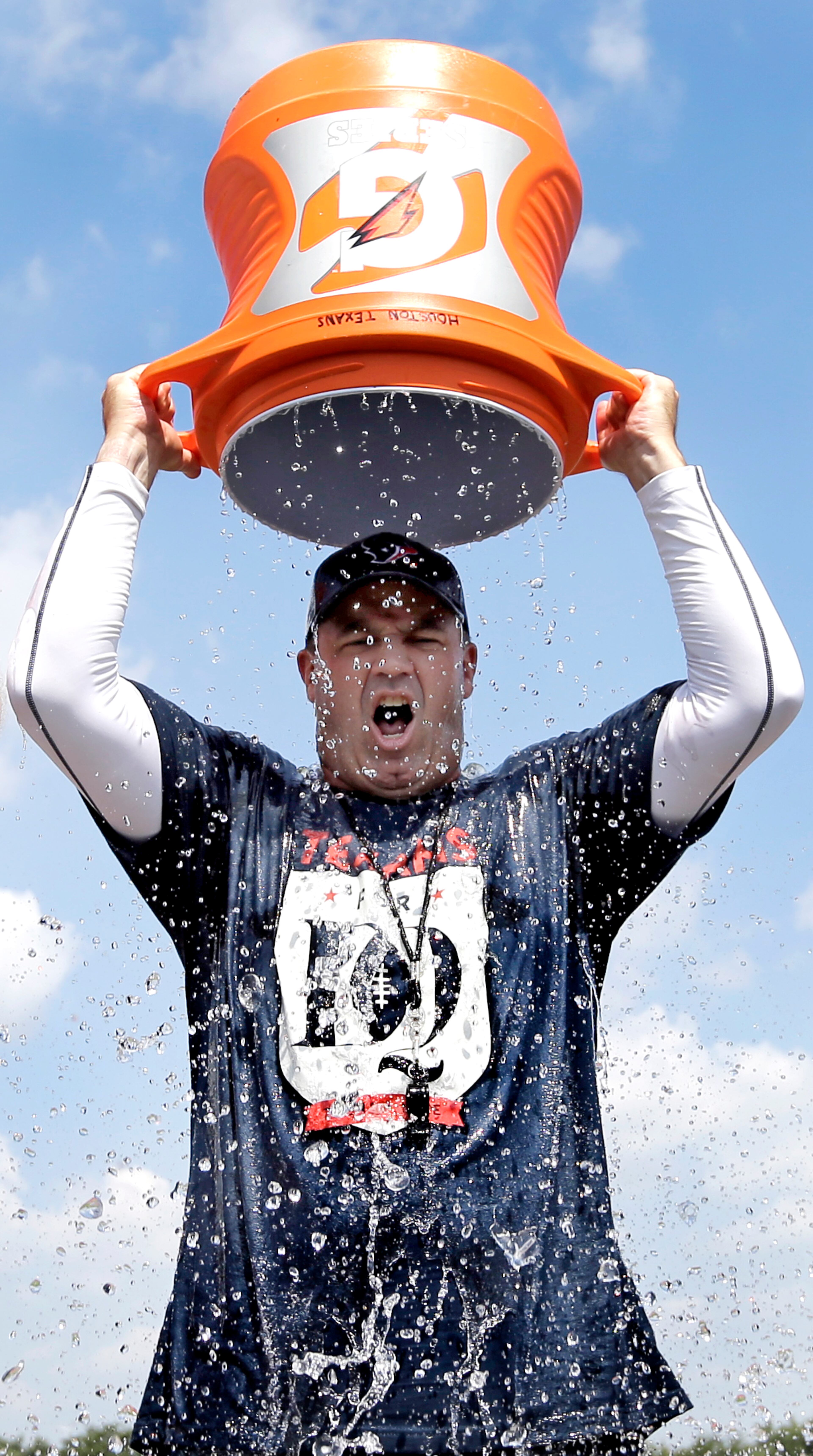 Houston Texans coach Bill O'Brien dunks ice water over his head after an NFL football training camp practice Thursday, Aug. 14, 2014, in Houston. O'Brien was challenged by a reporter to take the ALS Ice Bucket Challenge to raise money for the ALS Association. The challenge, a social media phenomenon, is part of a program launched by the ALS Association to raise money for fighting ALS, also known as Lou Gehrig's disease. Participants challenge others on video to do it or donate money to ALS before dumping ice cold water over their heads.(AP Photo/David J. Phillip)