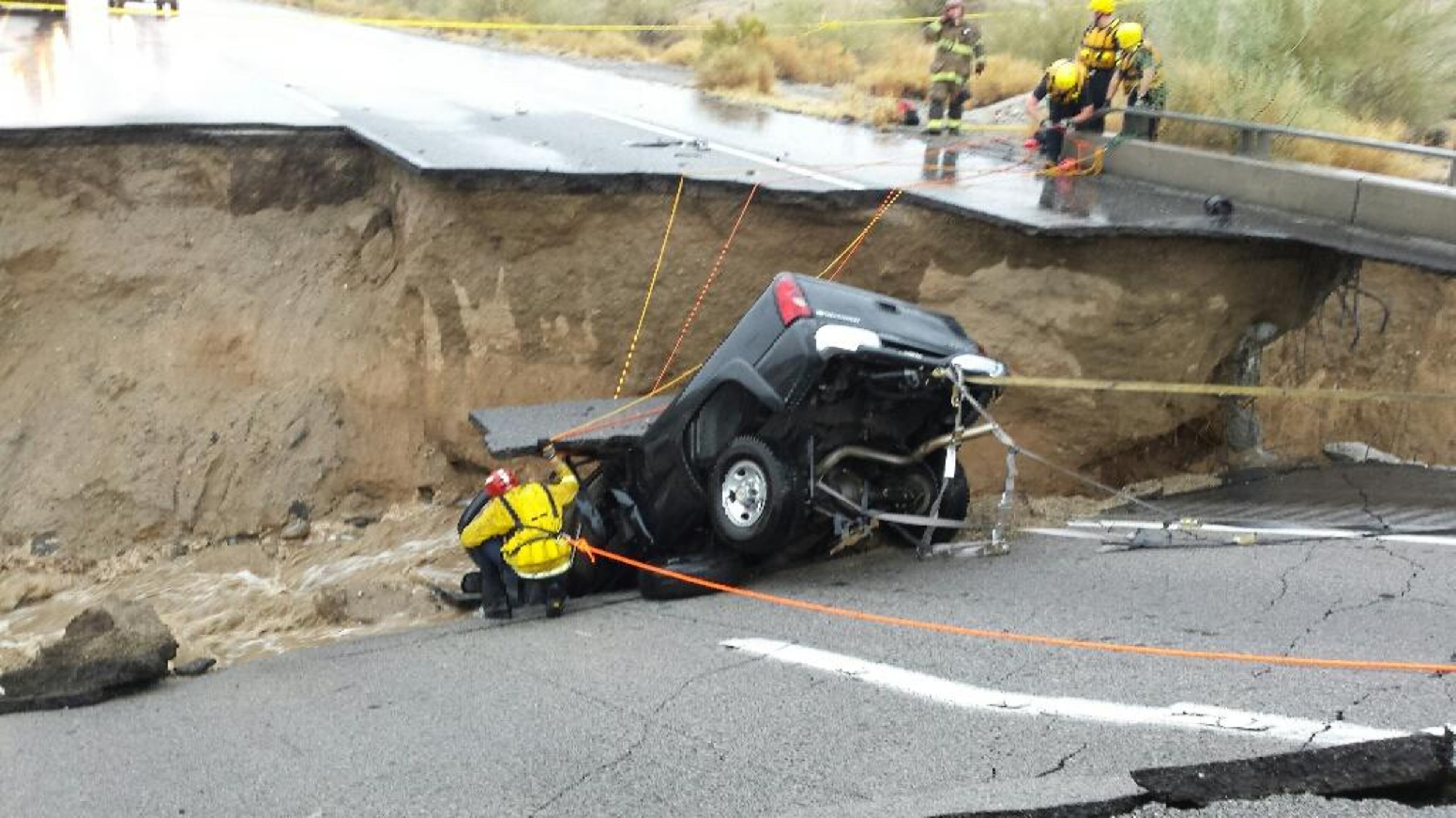 In this photo provided by the CAL FIRE/Riverside County Fire Department, emergency crews respond after a pickup truck crashed into the collapse of an elevated section of Interstate 10, Sunday, July 19, 2015, in Desert Center, Calif. The bridge, which carries the eastbound interstate about 15 feet above a normally dry wash, snapped and ended up in the flooding water below, the California Highway Patrol said, blocking all traffic headed toward Arizona. (Chief Geoff Pemberton/CAL FIRE/Riverside County Fire via AP)