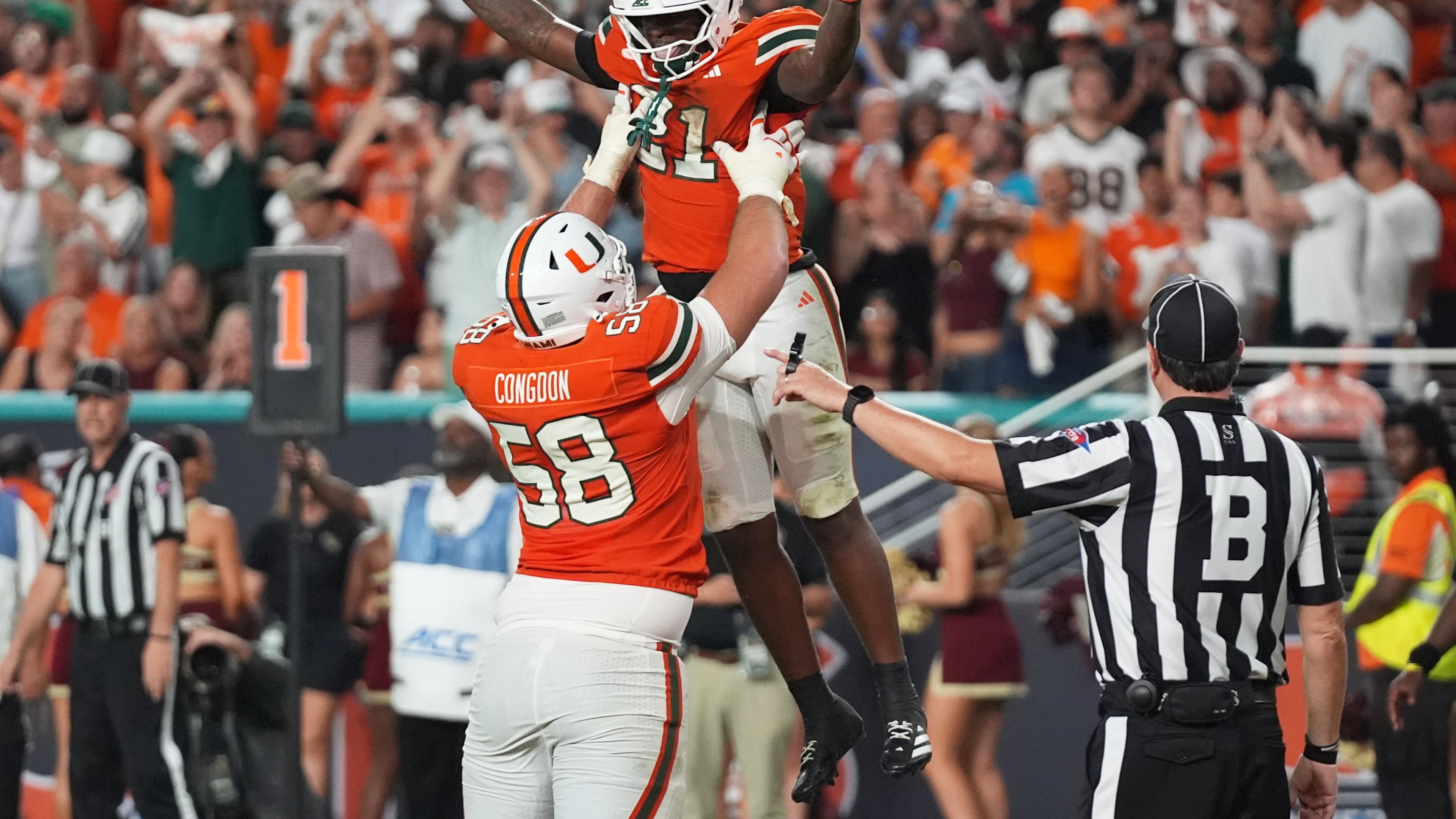 Miami running back Javian Mallory (21) celebrates with offensive lineman Ben Congdon (58) after scoring a touchdown during the second half of an NCAA college football game against Florida State, Saturday, Oct. 17, 2026, in Miami Gardens, Fla. (AP Photo/Lynne Sladky)