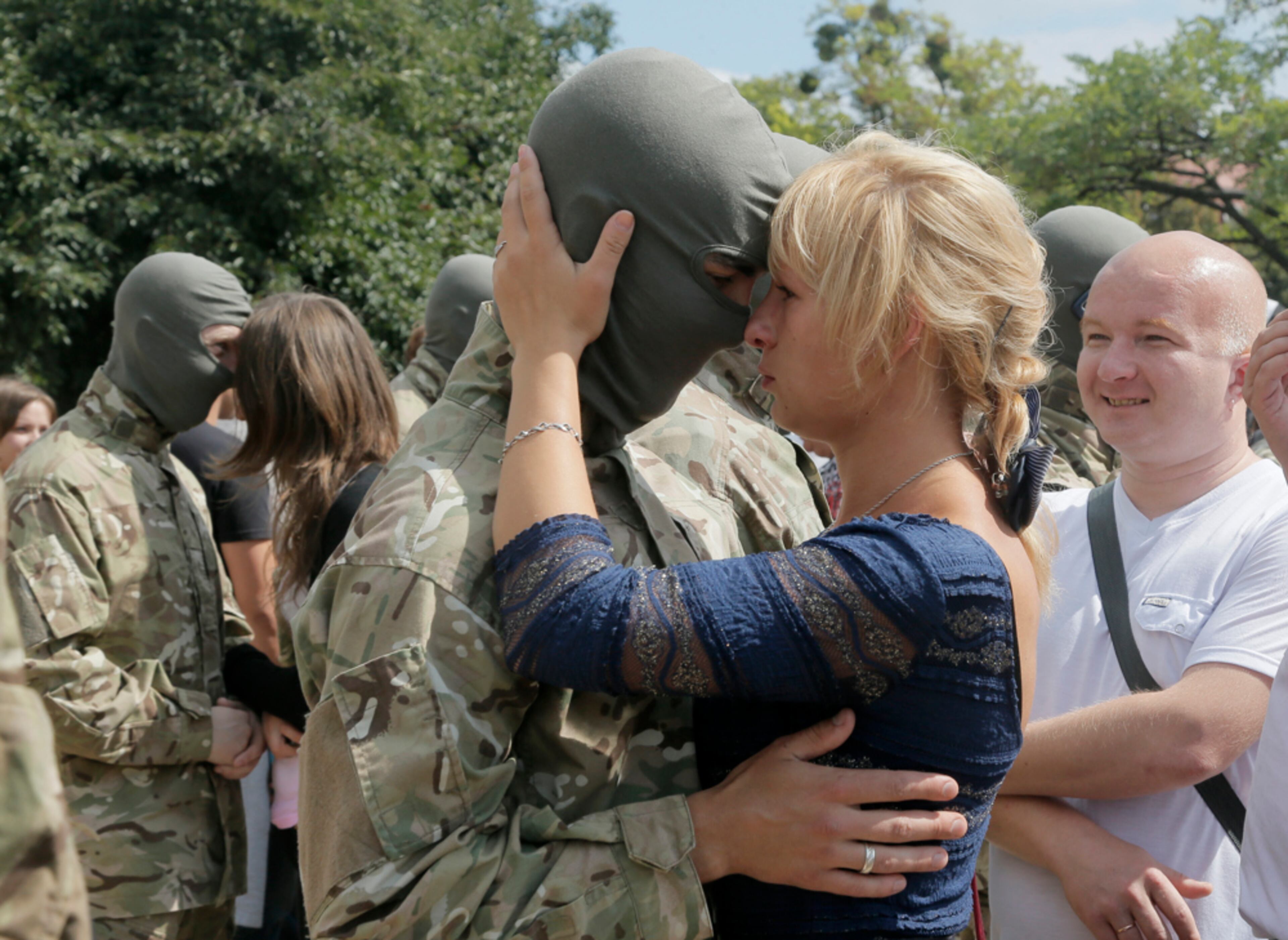 LET'S JUST KISS AND SAY GOODBYE--Friends and relatives say goodbye to volunteers before they were sent to the eastern part of Ukraine to join the ranks of special battalion "Azov" fighting against pro-Russian separatists, in Kiev, Ukraine, Sunday, Aug. 17, 2014. Ukraine's national security council said government forces captured a district police station in Luhansk after bitter clashes, but the government also reported Sunday that separatists have shot down a Ukrainian fighter plane in Luhansk region after army troops entered deep inside a rebel-controlled city in the east. (AP Photo/Efrem Lukatsky)