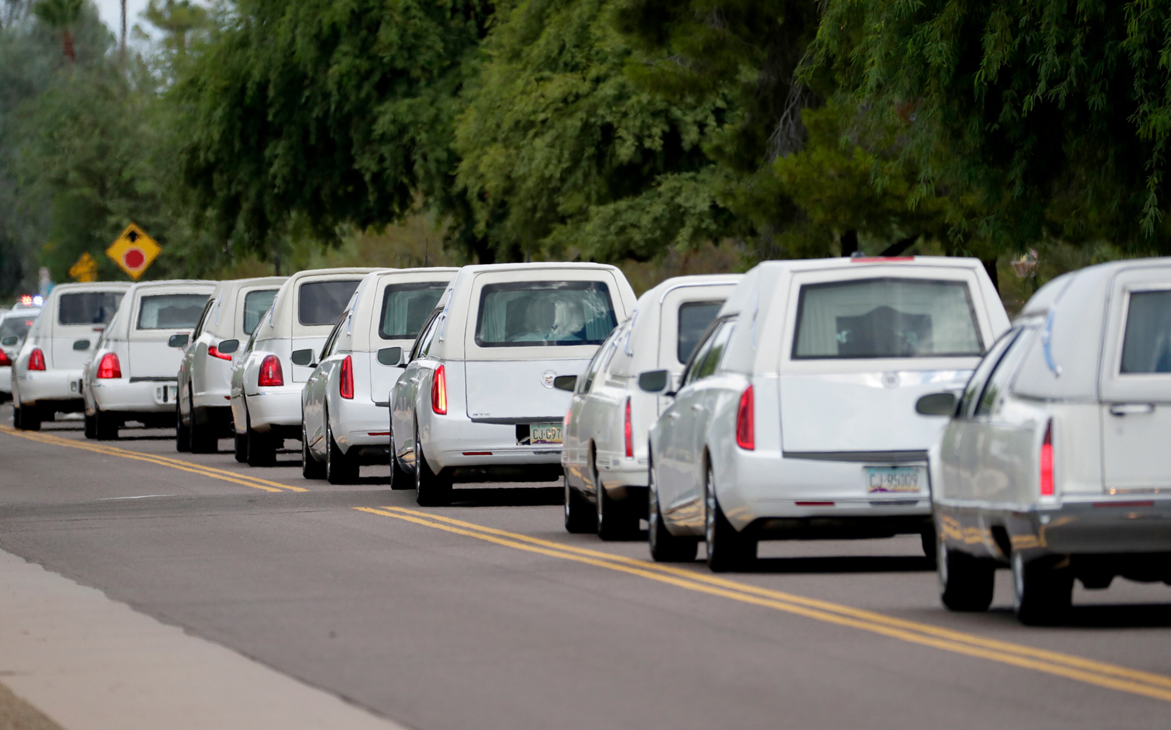 Hearses carrying family members who were killed in a flash flood leave St. Patrick Catholic Church, Tuesday, July 25, 2017, in Scottsdale, Ariz. Ten members of an extended Arizona family were killed earlier this month in flash flood while they celebrated a birthday. (AP Photo/Matt York)