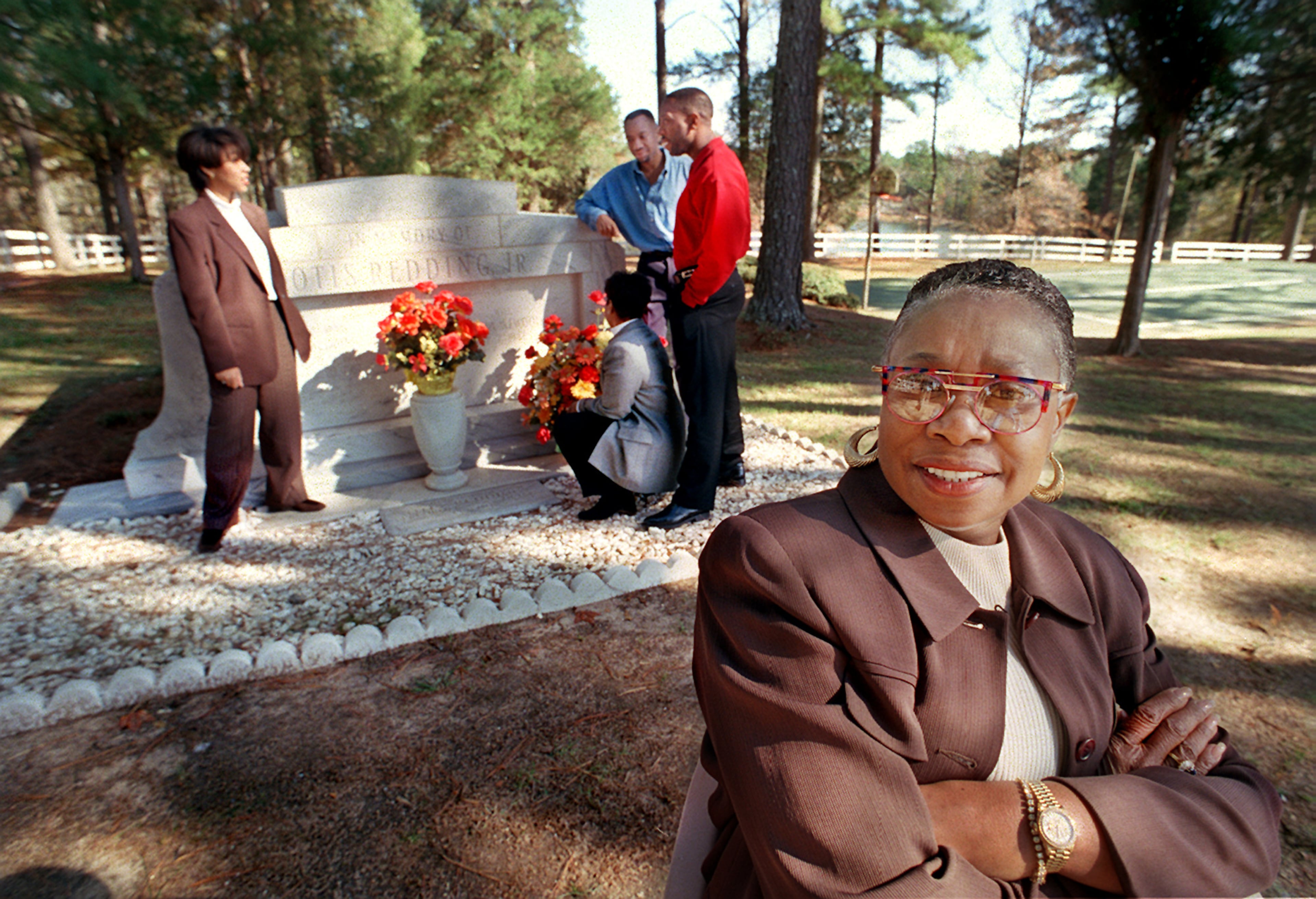 Zelma Redding (left) reflects at the grave of Otis Redding with her children (left to right): Dee Dee Redding, Otis Redding III, Dexter Redding and Karla Redding (kneeling). (Joey Ivansco/AJC 1997)