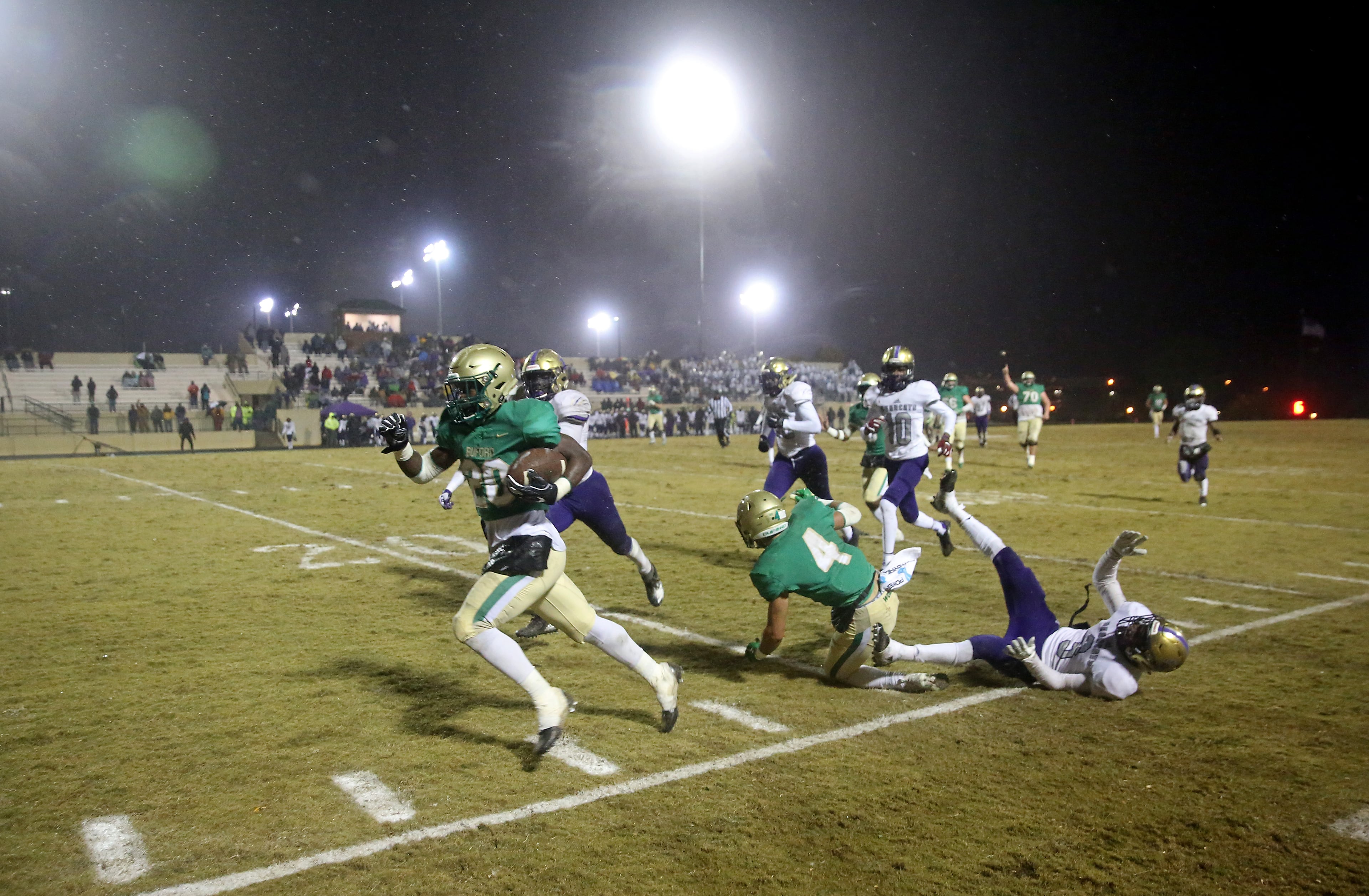 November 23, 2018 - Buford, Ga: Buford running back Elijah Turner (20) runs down the sideline after Buford wide receiver Austin Turner (4) blocked Bainbridge defensive back Deyon Bouie (3) in the second half at Buford High School Friday, November 23, 2018, in Buford, Ga. A penalty was called on Buford's Turner for the block and the run was negated. Buford lost to Bainbridge 23-20. This is the quarter finals of the Class 5A state playoffs. (JASON GETZ/SPECIAL TO THE AJC)
