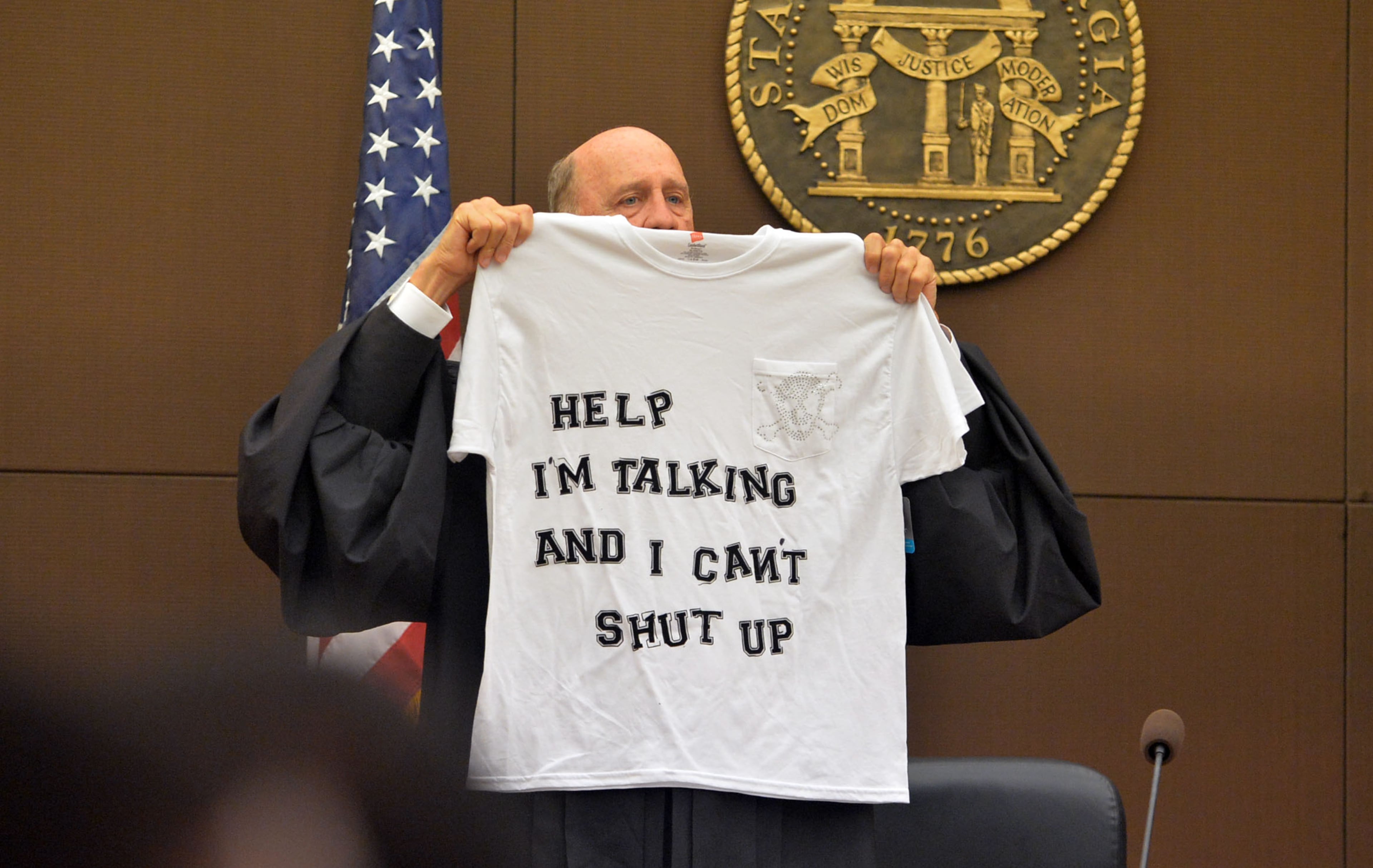 Judge Jerry Baxter holds up a T-shirt he bought for a "dubious achievement award" that he hopes not to give out during the course of the trial. The prosecution laid out its case to kick off the Atlanta Public Schools test-cheating trialin Fulton County Superior Court, Monday on Sept. 29, 2014. Not all 12 defense lawyers would make opening statements; some planned to reserve theirs until after the prosecution presented its case. KENT D. JOHNSON / KDJOHNSON@AJC.COM