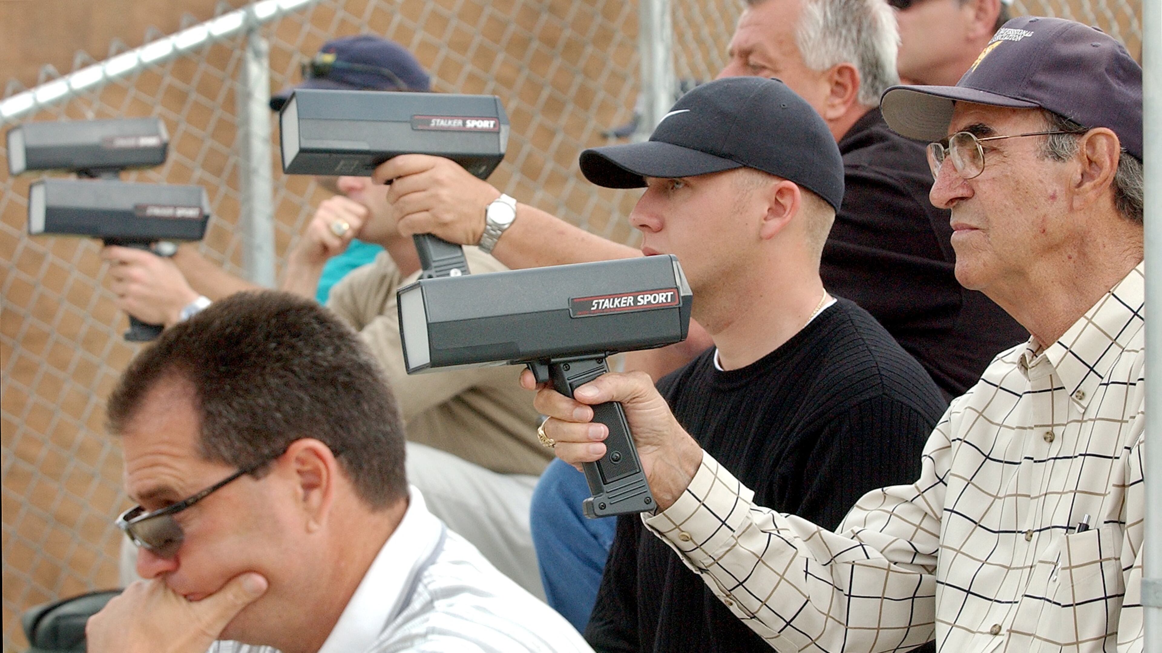 Pro scouts check pitch speeds at a Georgia high school game. (AJC file photo)