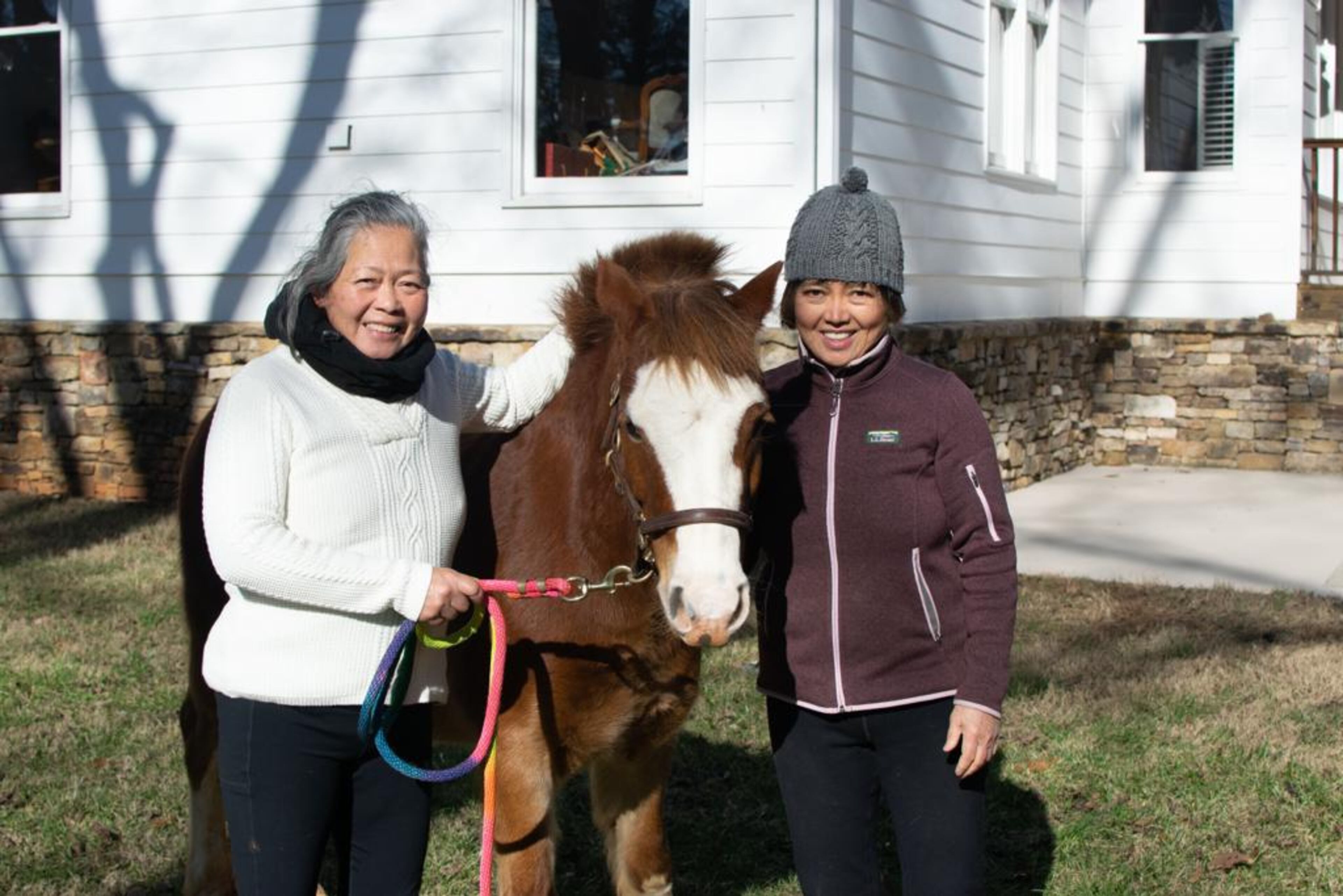 Joy Lim Nakrin's aunt, 74-year-old Betty Lim King, and her mother, 72-year-old Teresita Lim King, working with owner surrender Prince the pony in a cooler season. (Courtesy of Joyous Acres)