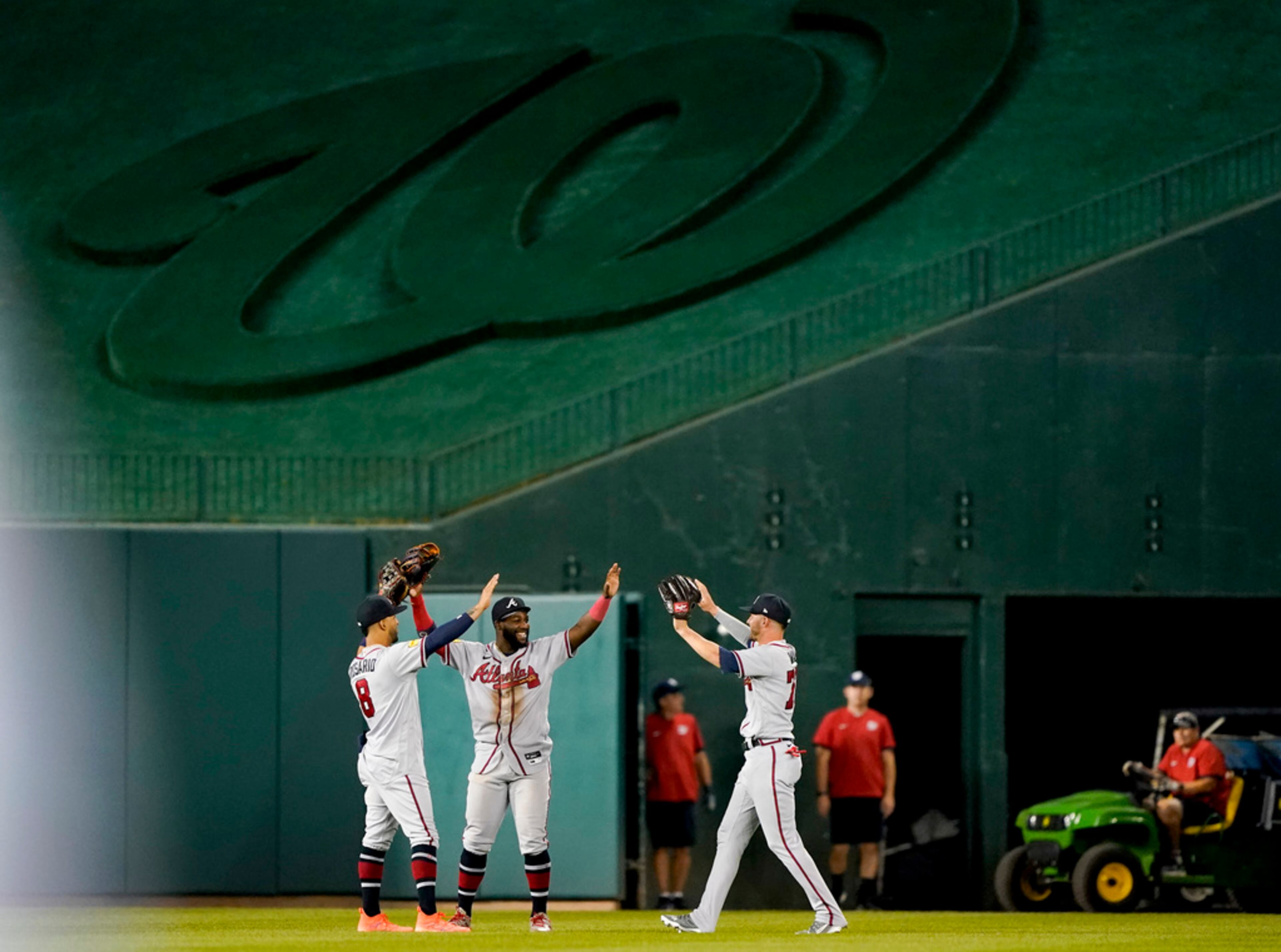 Atlanta Braves outfielders Eddie Rosario, Michael Harris II and Forrest Wall, from left, celebrate after the team's baseball game against the Washington Nationals at Nationals Park, Thursday, Sept. 21, 2023, in Washington. The Braves won 10-3. (AP Photo/Andrew Harnik)