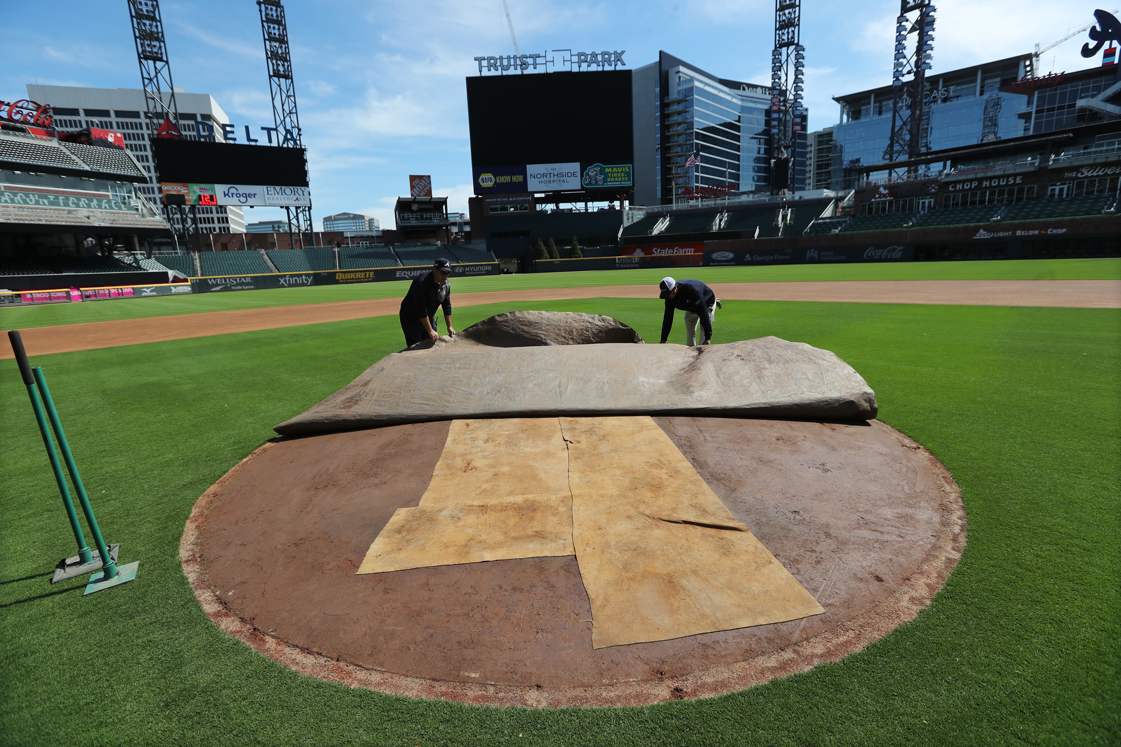 Braves field managers Anthony DeFeo (left) and Tyler Lenz (right) work on the pitcher's mound at Truist Park. Curtis Compton ccompton@ajc.com