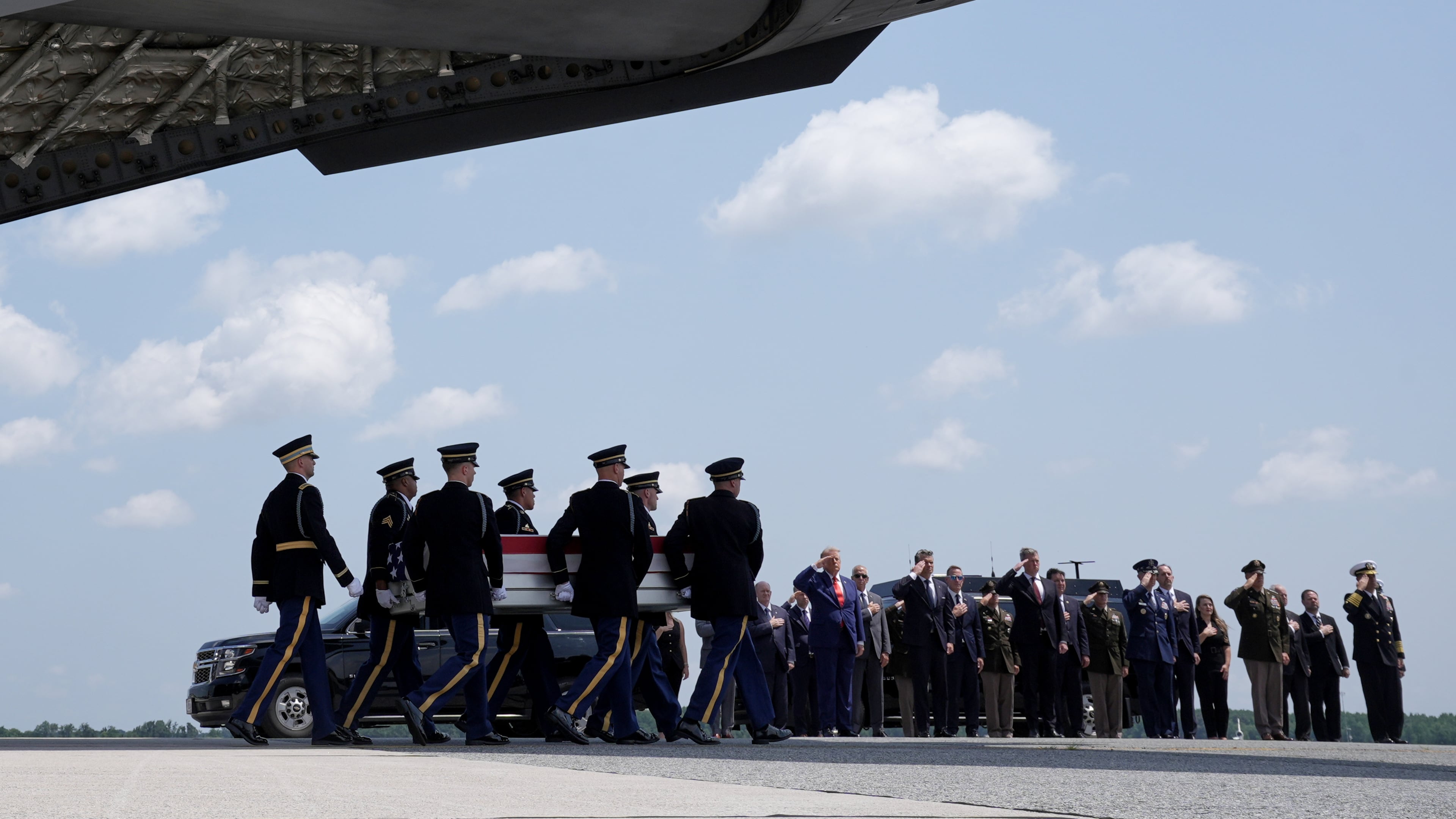 President Donald Trump and Secretary of Defense Pete Hegseth and others, salute as a U.S. Army carry team moves a transfer case containing the remains of Sgt. Angel S. Rampersad, of Ozone Park, N.Y. Wednesday, July 22, 2026, at Dover Air Force Base, Del. (AP Photo/Matt Rourke)