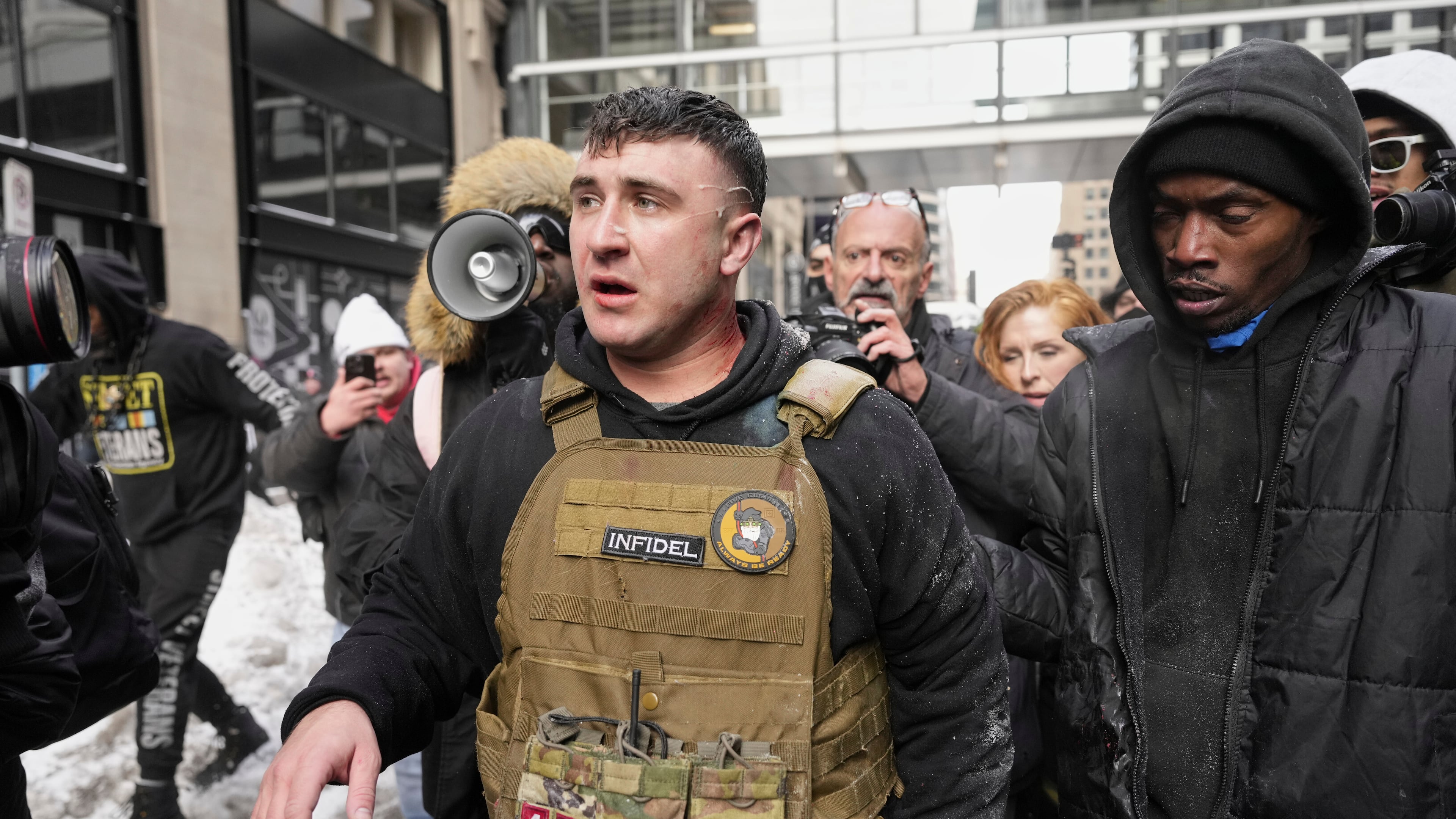 FILE - Jake Lang, center, walks away from counter protesters after an altercation near Minneapolis City Hall, Saturday, Jan. 17, 2026, in Minneapolis. (AP Photo/Yuki Iwamura,File)