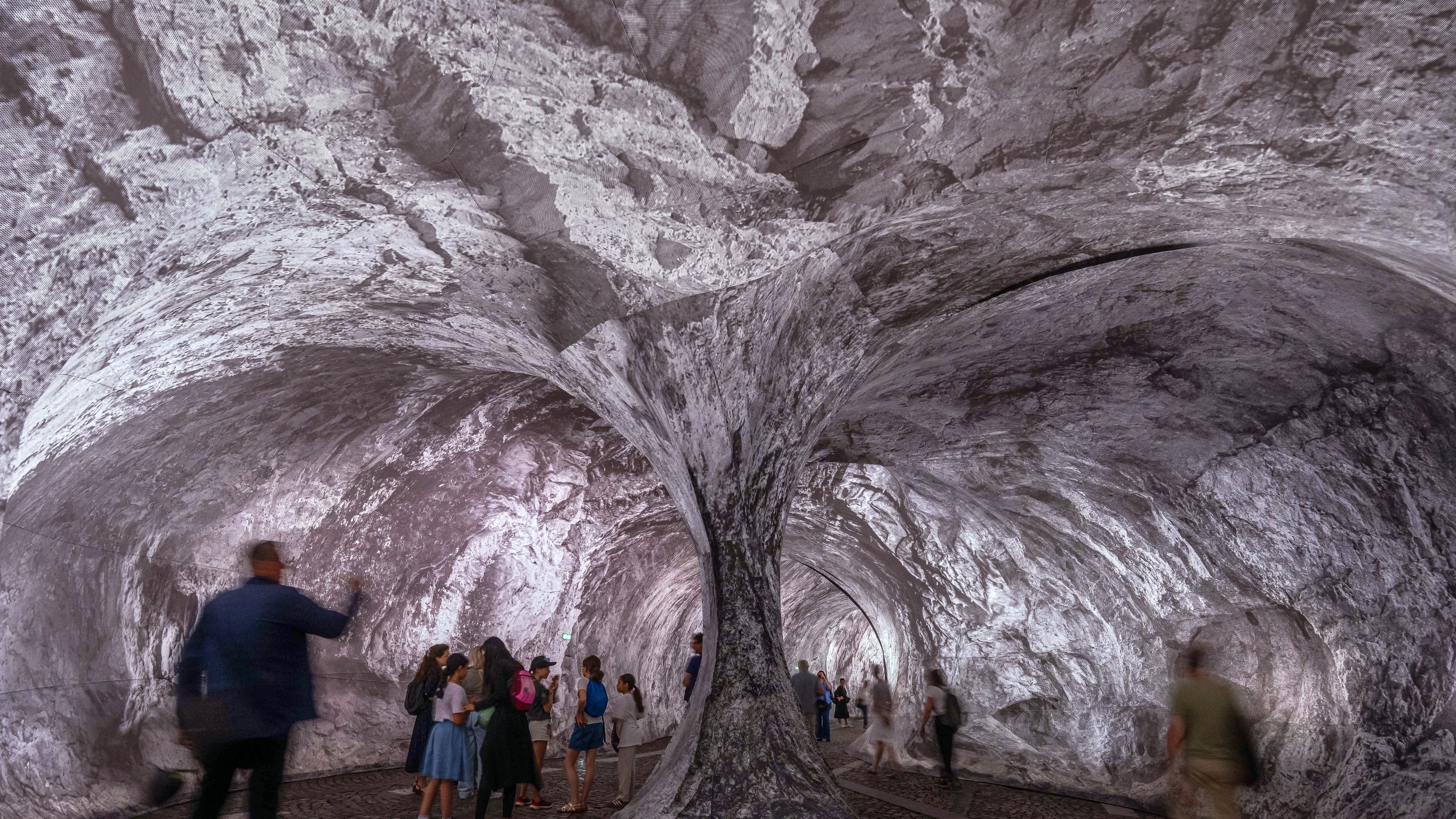 Visitors walk into the artwork "The Pont Neuf Cave" by French street artist JR on the Pont Neuf bridge, Tuesday, June 16, 2026, in Paris, open to the public from June 15 to 28. (AP Photo/Aurelien Morissard)