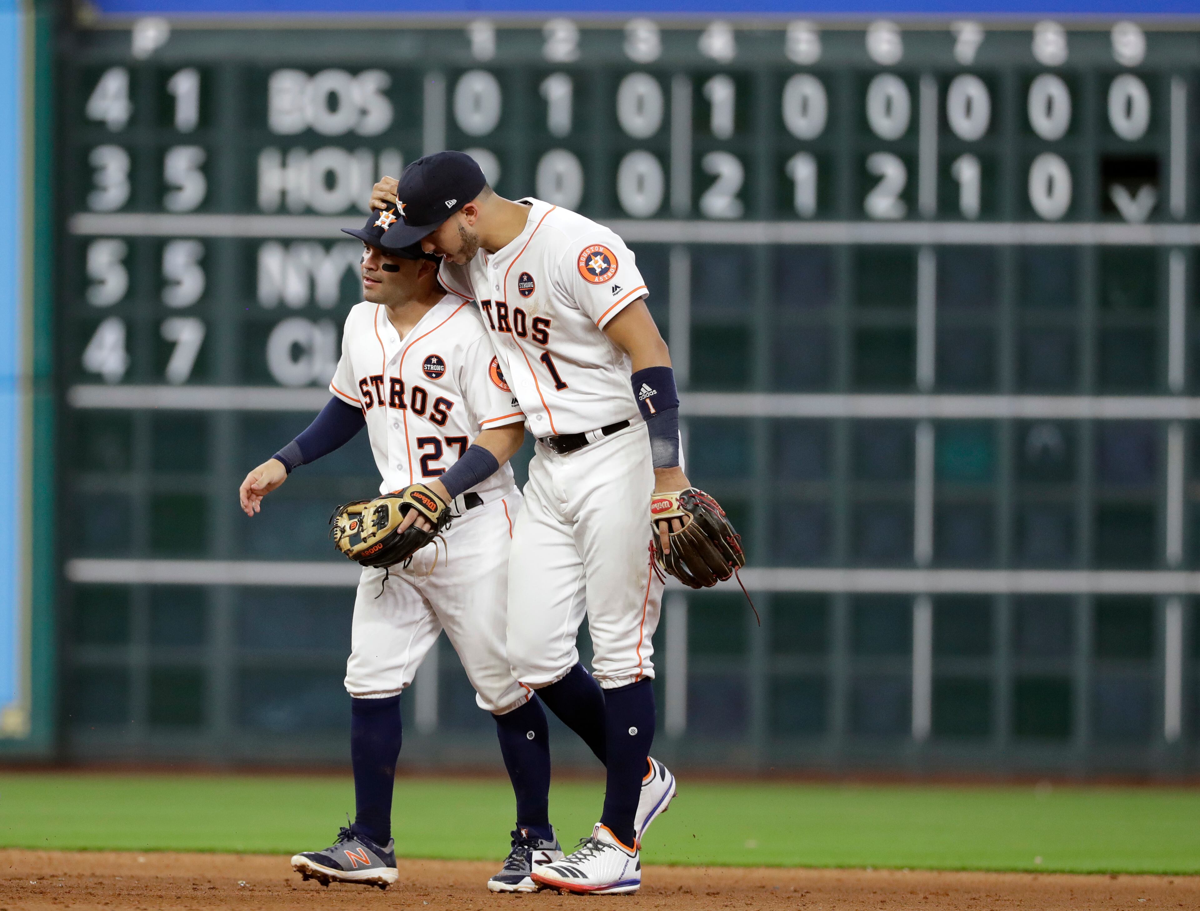 Houston Astros' Jose Altuve (27) and Carlos Correa (1) celebrate their win over the Boston Red Sox in Game 1 of baseball's American League Division Series, Thursday, Oct. 5, 2017, in Houston. Houston won 8-2. (AP Photo/David J. Phillip)