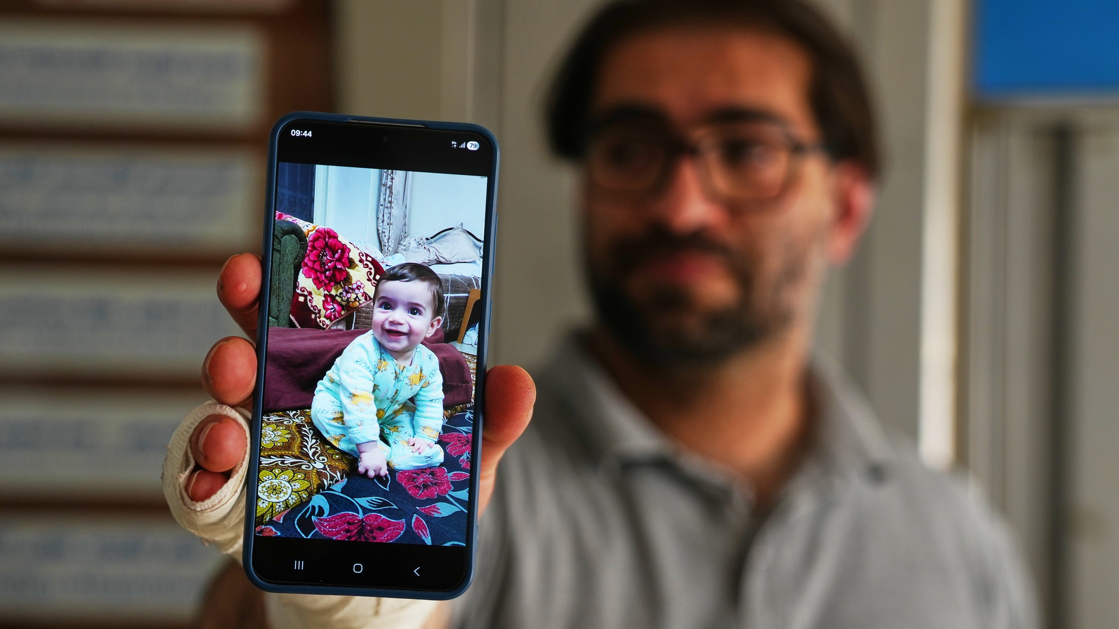Fahd Abu Haikal, 41 displays a mobile photo of his seven month old Palestinian baby boy Sam, who was killed on Friday when Israeli soldiers fired at the vehicle carrying him and his parents, in Tel Rumeida, at a hospital in the West Bank city of Hebron Saturday, June 6, 2026. (AP Photo/Mahmoud Illean)