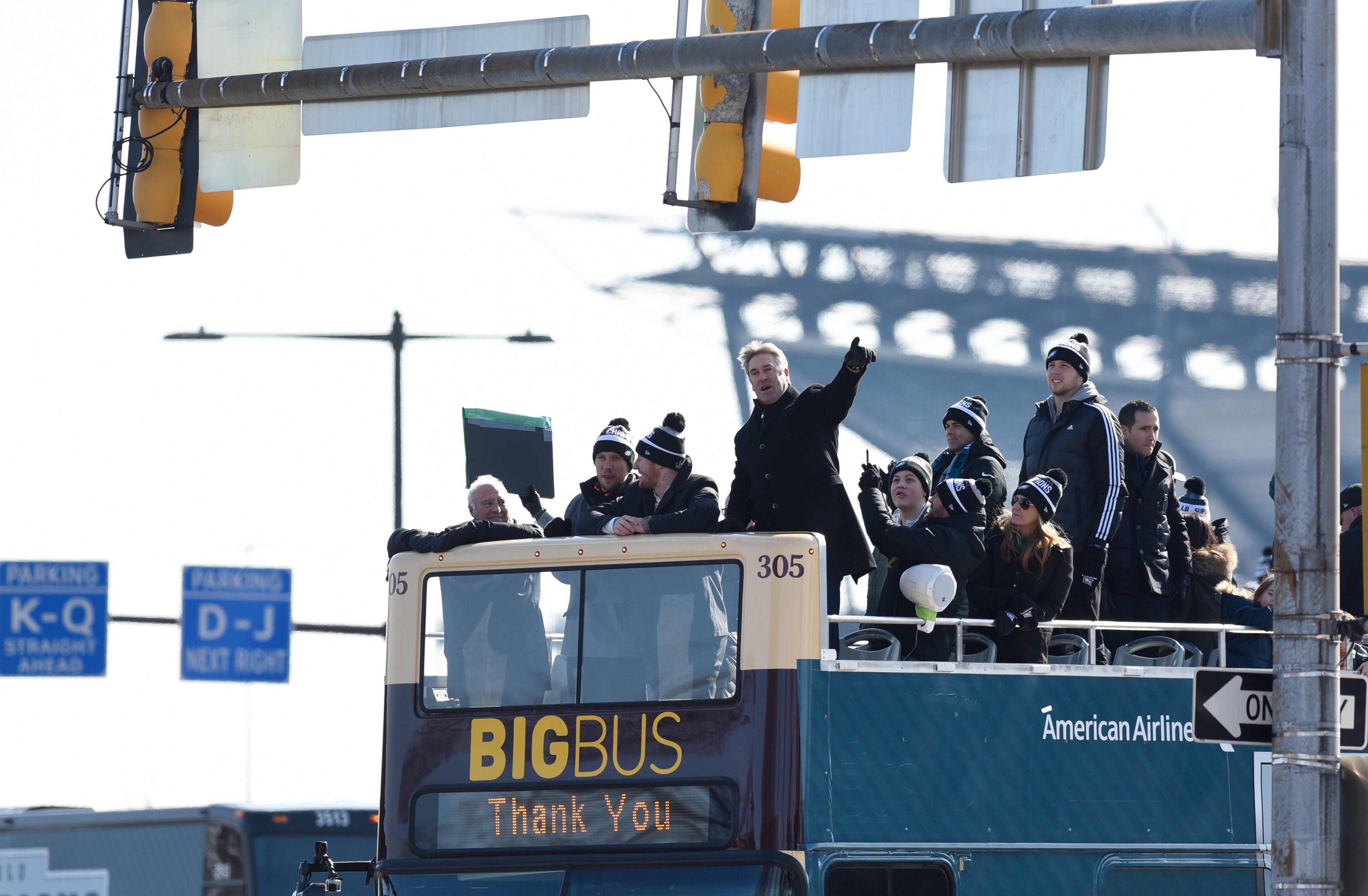 Philadelphia Eagles NFL football team head coach Doug Pederson points to the crowd gathered during the Super Bowl LII victory parade, Thursday, Feb 8, 2018, in Philadelphia. From left are team owner Jeffrey Lurie and quarterbacks Nick Foles and Carson Wentz. (AP Photo/Michael Perez)