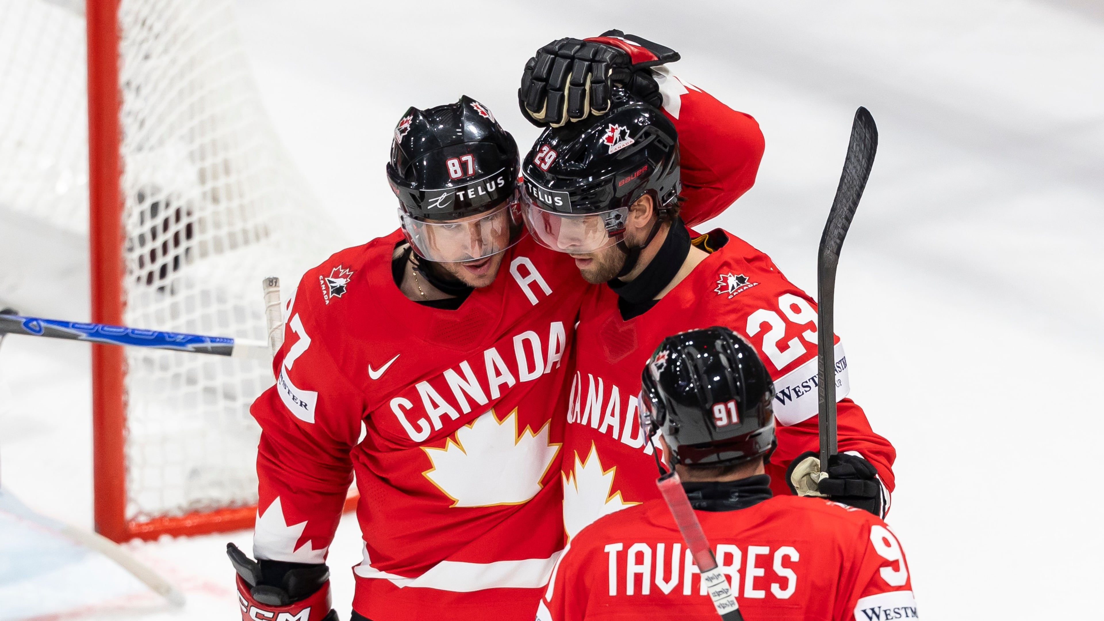 Canada's Parker Wotherspoon, center, celebrates his goal with Canada's Sidney Crosby, left, and Canada's John Tavares, right, during the 2026 IIHF Men's Ice Hockey World Championship preliminary round group B game between Canada and Denmark, in Fribourg, Switzerland, Monday, May 18, 2026. (Cyril Zingaro/Keystone via AP)