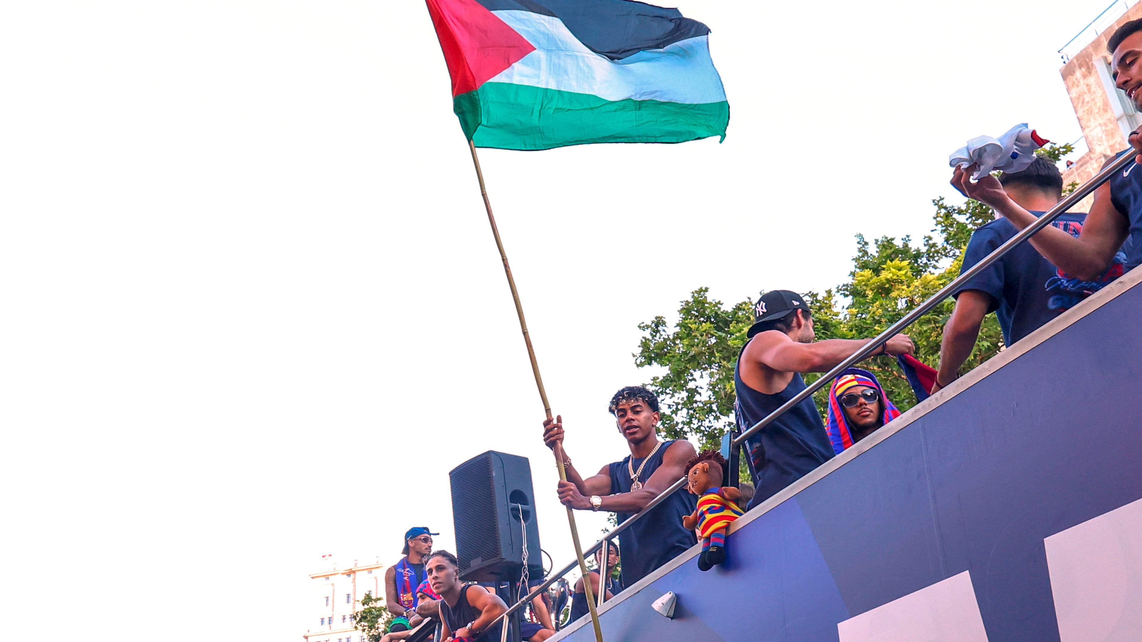 FC Barcelona player Lamine Yamal holds a Palestinian flag as he celebrates with his team atop a bus after winning the Spanish La Liga title in Barcelona, Spain, Monday, May 11, 2026. (AP Photo)