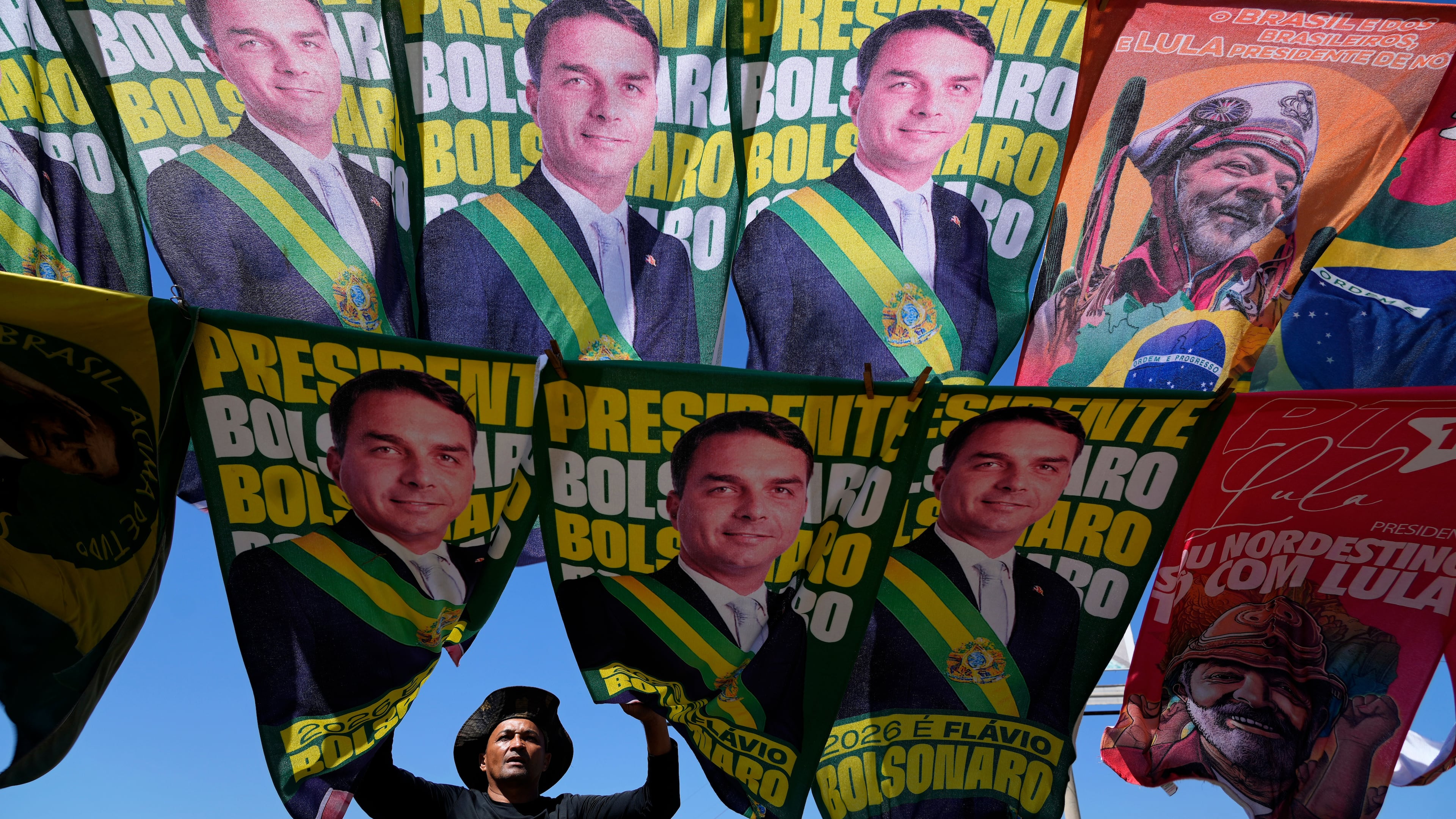 FILE - A street vendor sells campaign flags of presidential candidates Sen. Flavio Bolsonaro and current President Luiz Inacio Lula da Silva, who is running for reelection, in Brasilia, Brazil, Sept. 29, 2026. (AP Photo/Eraldo Peres, File)