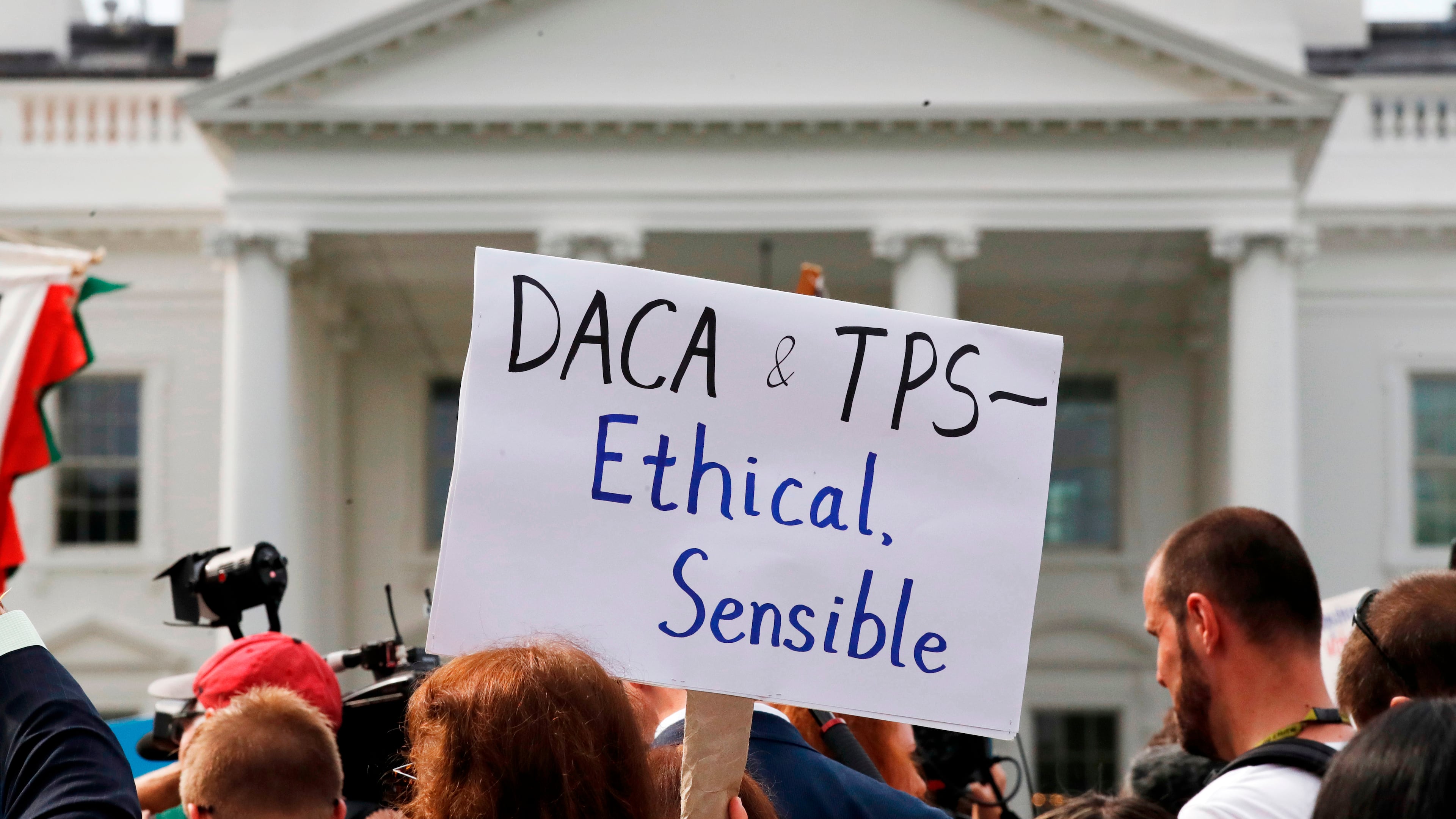 A person holds up a sign in support of the Deferred Action for Childhood Arrivals, known as DACA, and Temporary Protected Status programs during a rally in support of DACA and TPS outside of the White House, in Washington, Sept. 5, 2017. (AP Photo/Jacquelyn Martin, file)