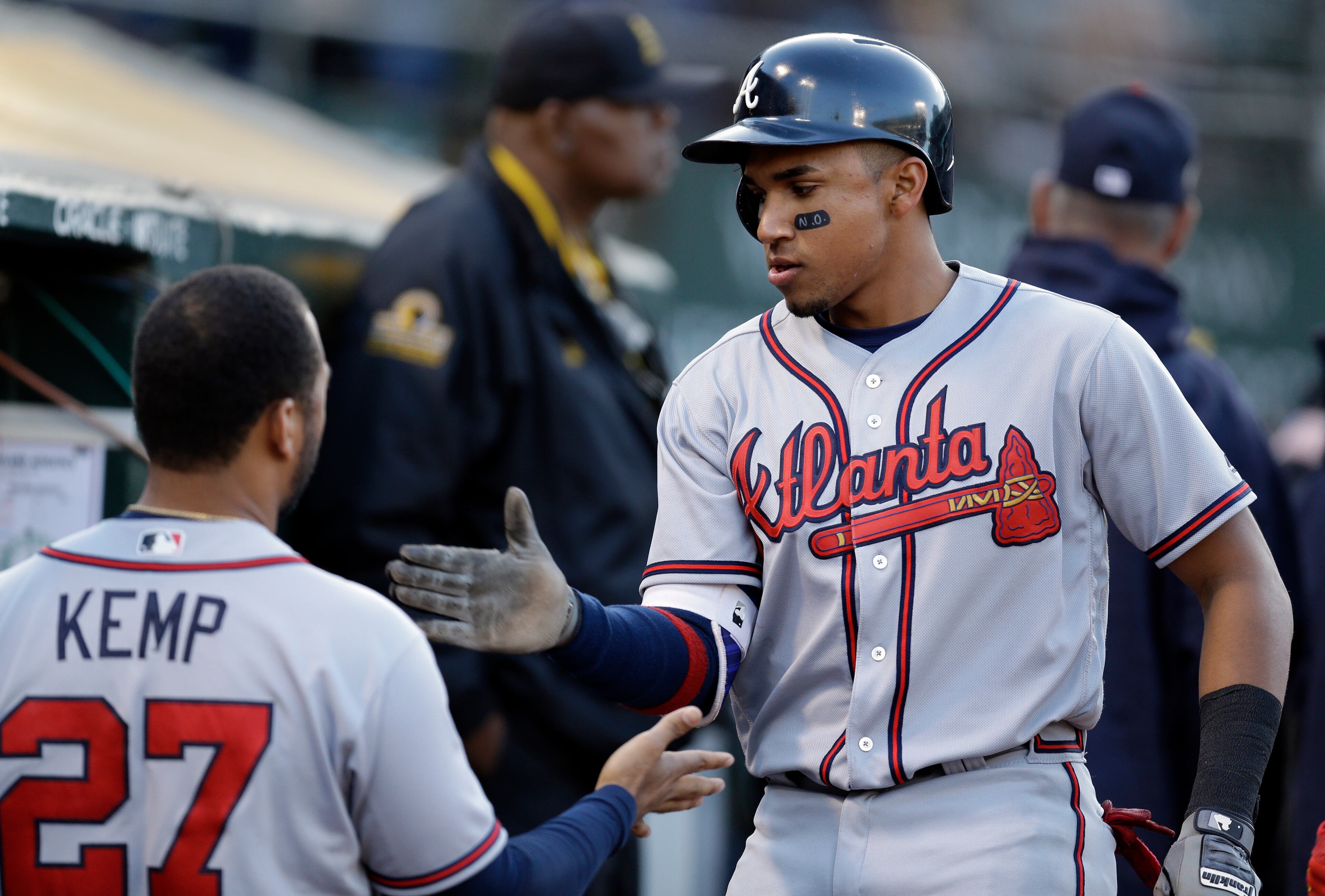 Atlanta Braves' Johan Camargo, right, is congratulated by Matt Kemp (27) after scoring against the Oakland Athletics during the third inning of a baseball game Friday, June 30, 2017, in Oakland, Calif. Camargo scored on a double by Braves' Dansby Swanson. (AP Photo/Ben Margot)