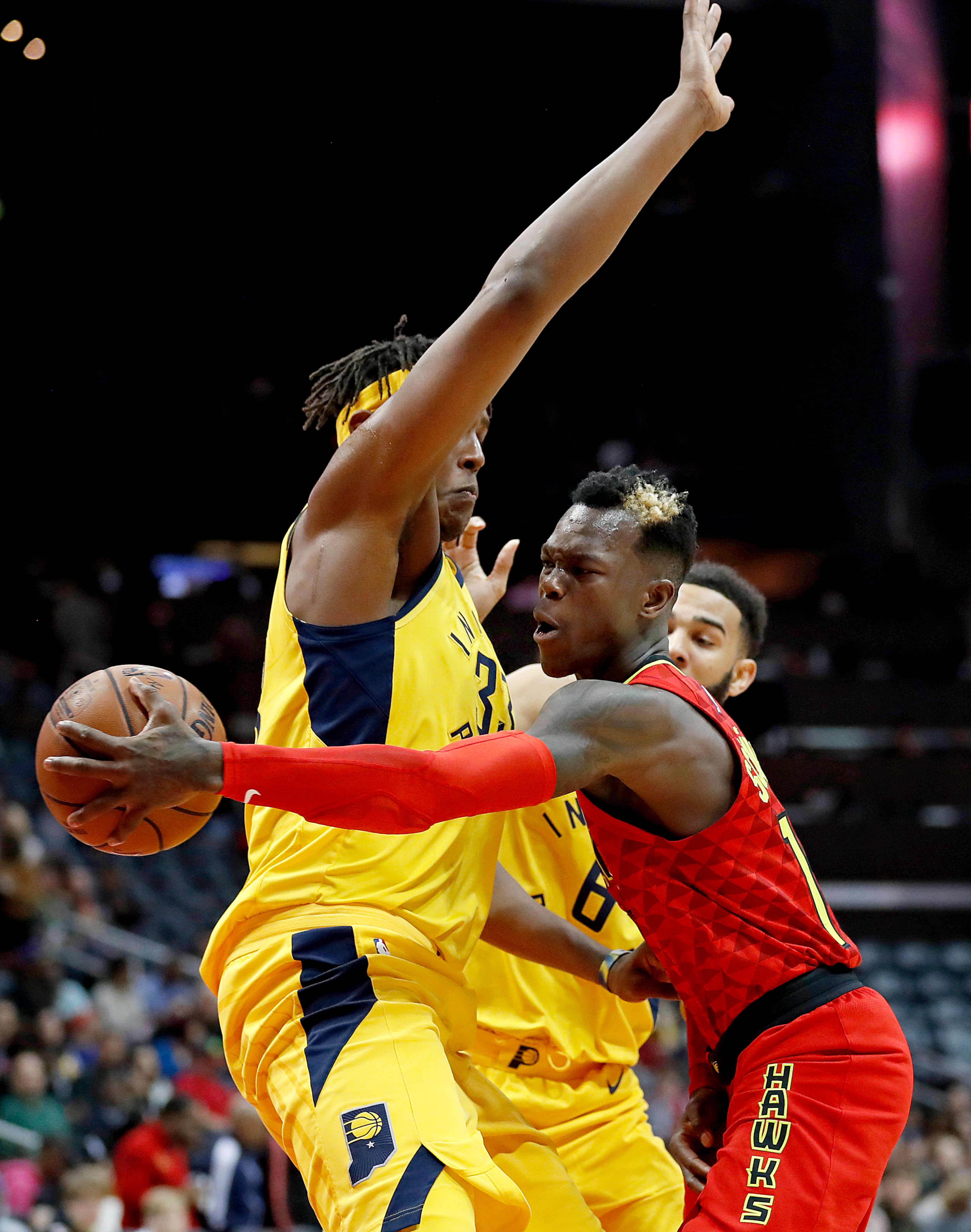 Atlanta Hawks' Dennis Schroder, right, of Germany, passes the ball behind the back of Indiana Pacers' Myles Turner in the first quarter of an NBA basketball game in Atlanta, Wednesday, Dec. 20, 2017. (AP Photo/David Goldman)