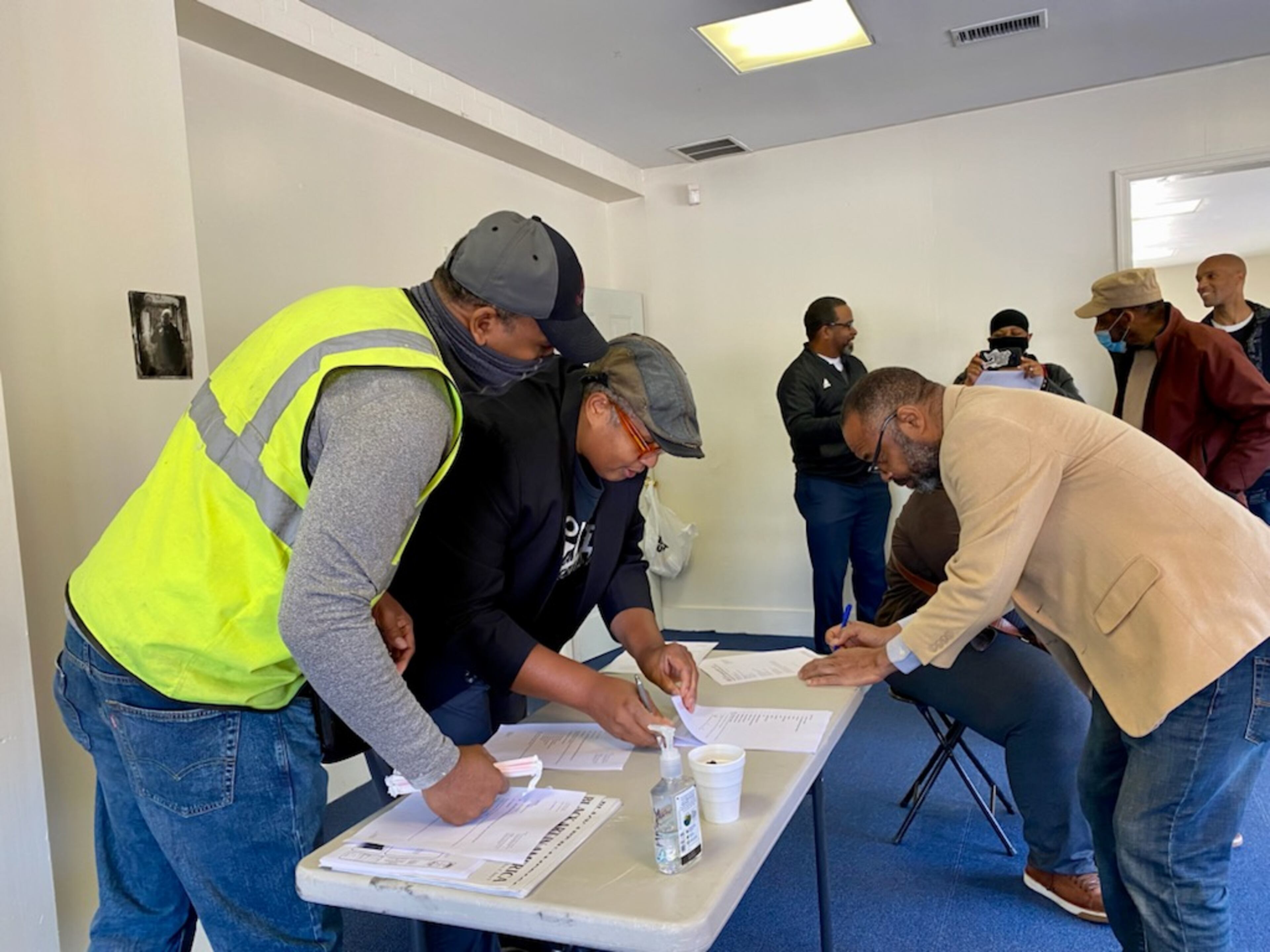 Najee Dorsey looks over documents as he prepares to sign the contract with Star construction to build the new facility in East Point.