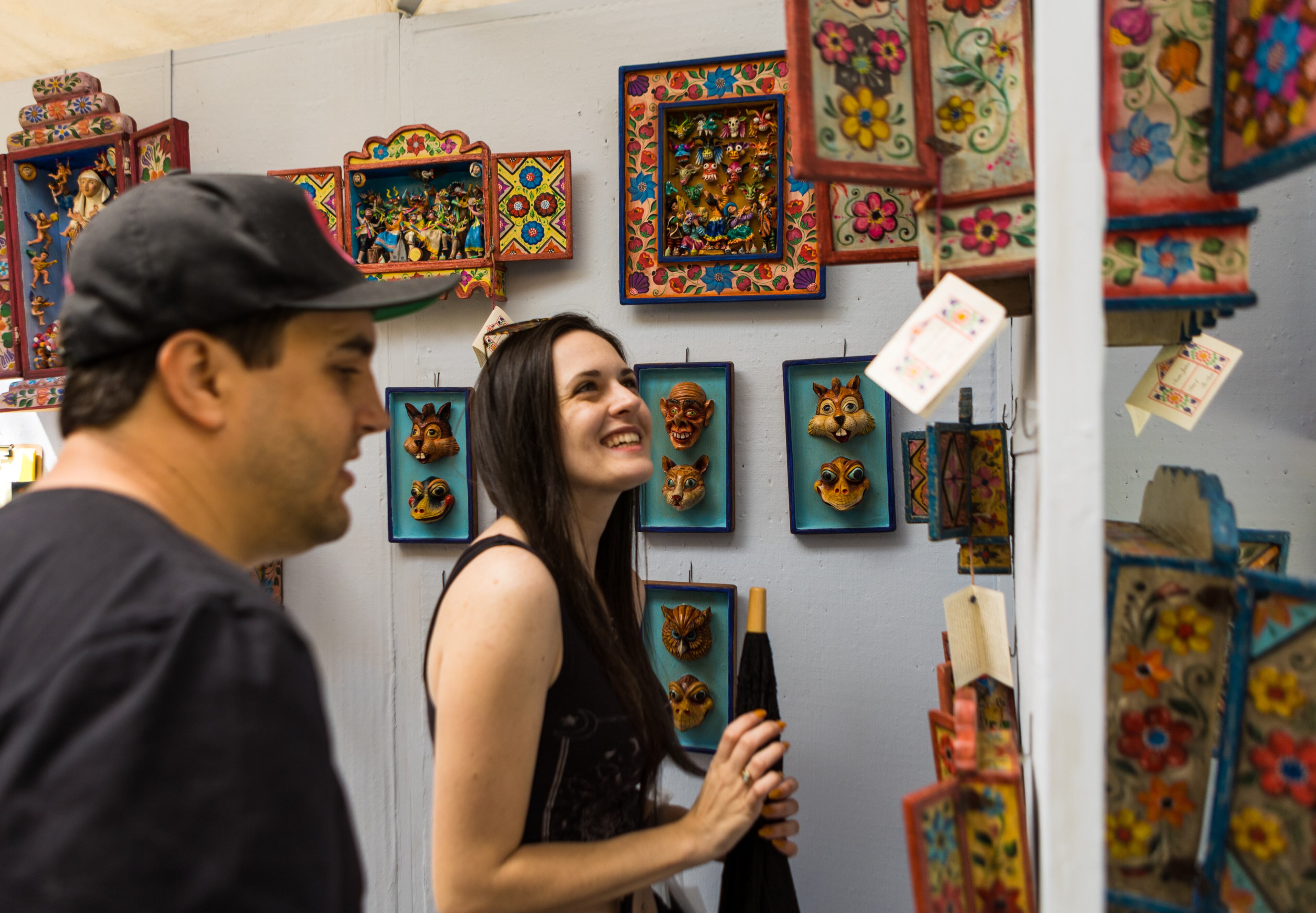 Sarah Norris and Mac Wallace of Decatur take a closer look at the retablos made by Nicario Jimenez at the 86th annual Atlanta Dogwood Festival in Piedmont Park on Sunday, April 10, 2022. The handmade retablos are portable boxes with intricate figures telling a story. (Jenni Girtman for The Atlanta Journal-Constitution)