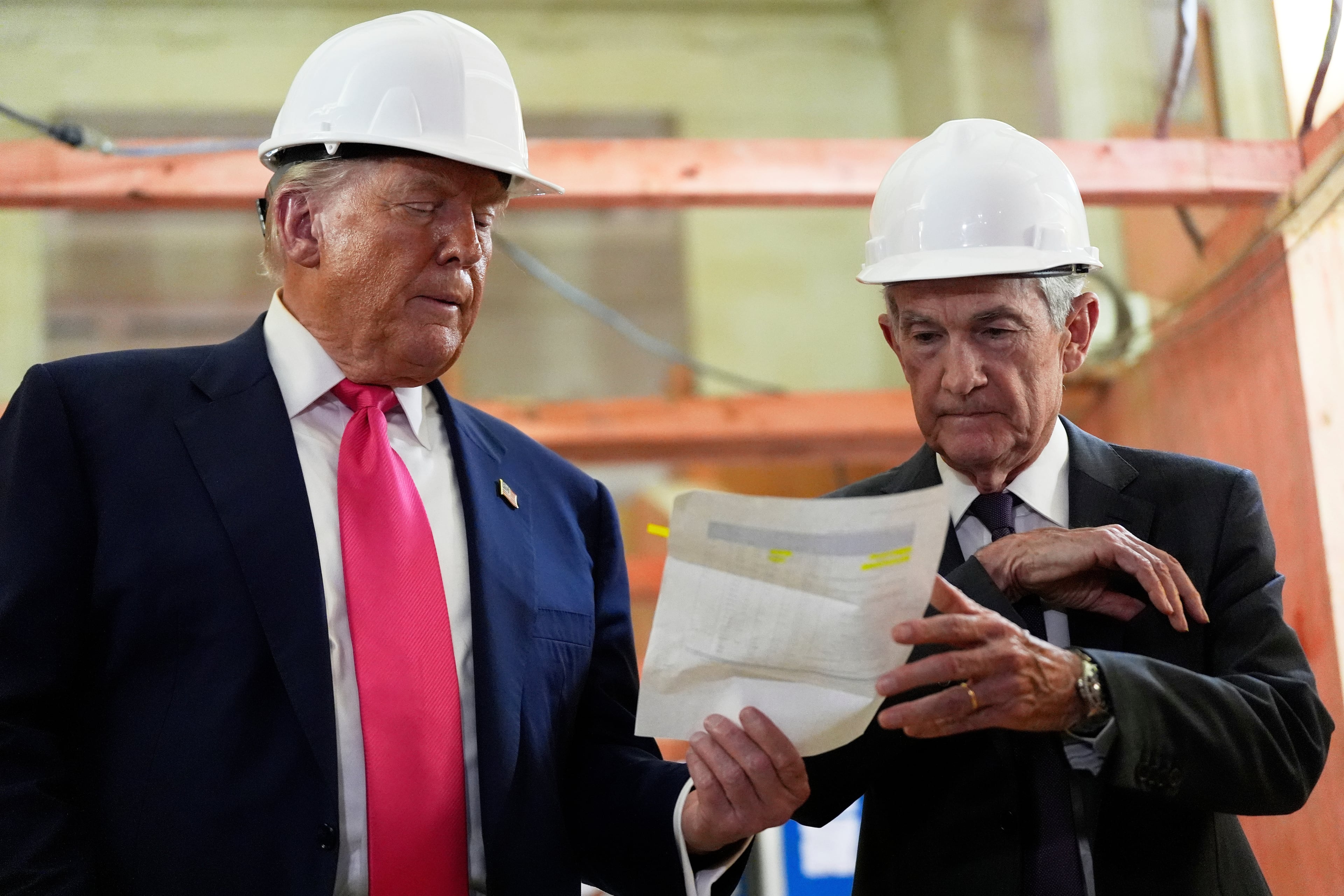 President Donald Trump (left) and Federal Reserve Chair Jerome Powell look over a document of cost figures during a visit to the Federal Reserve last July. (Julia Demaree Nikhinson/AP)