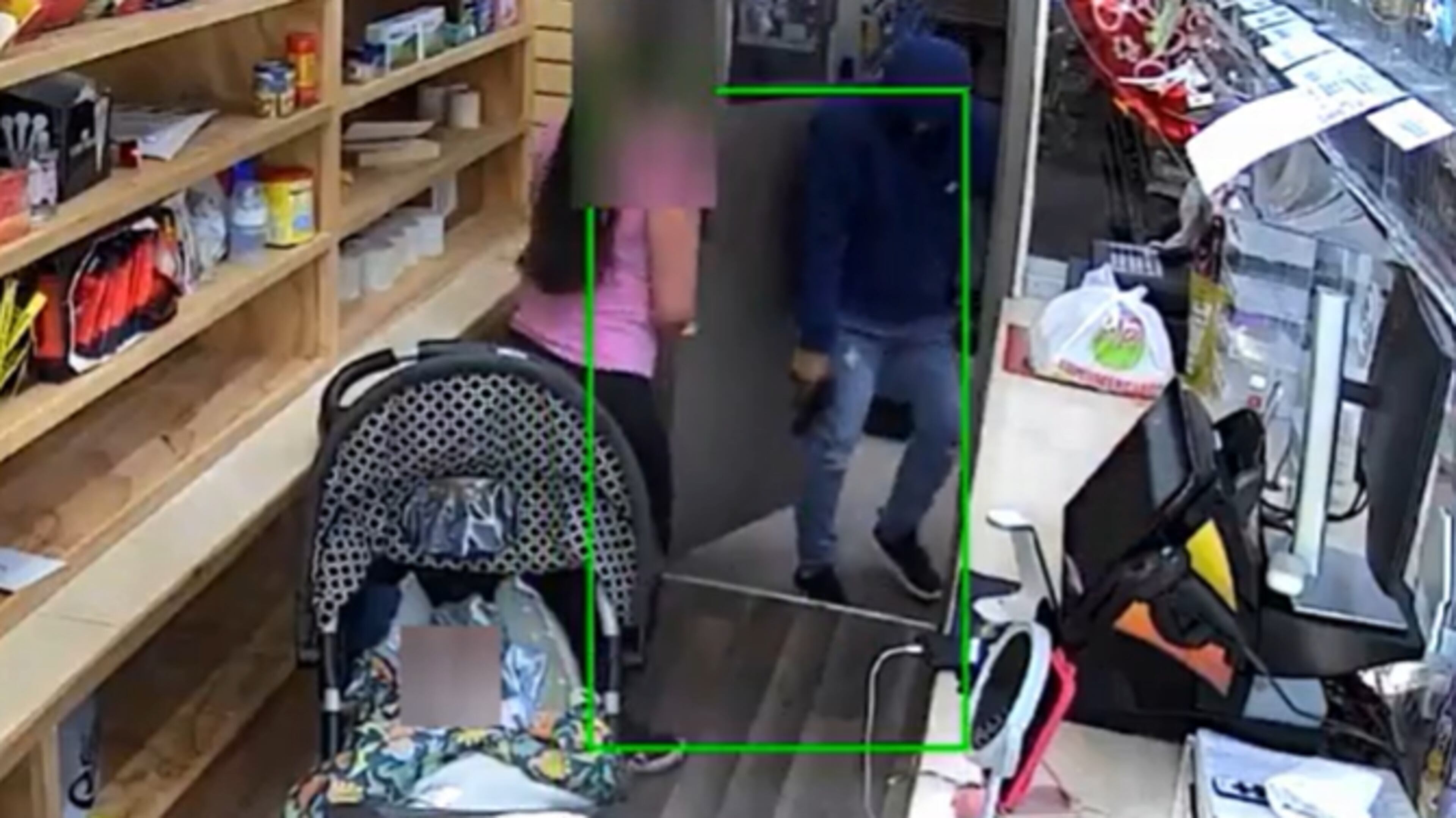 A store clerk is confronted by an armed man at a Gwinnett County grocery store on May 13. Her baby was in a stroller feet away during the robbery. (Gwinnett County Police Department)
