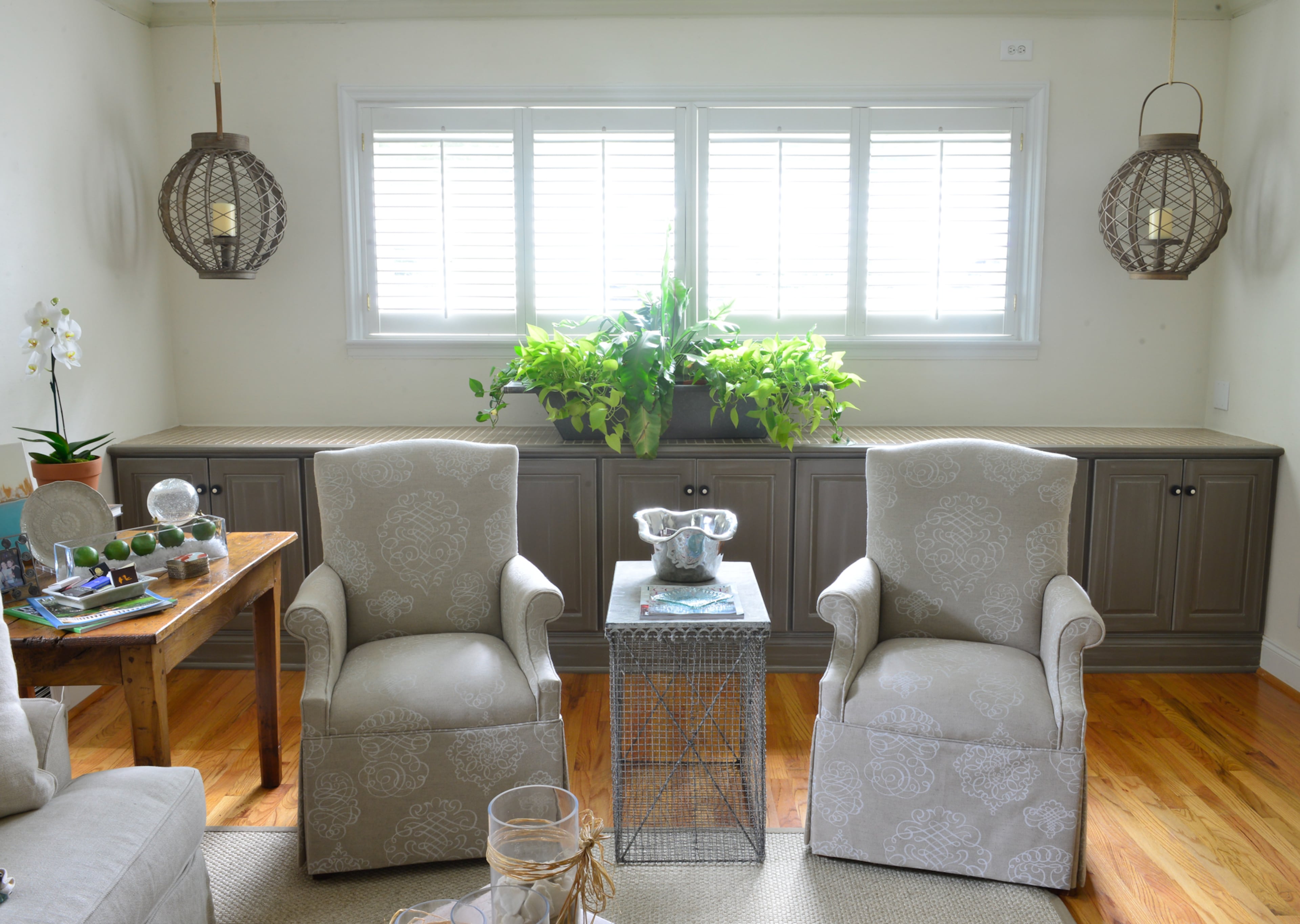 In the living room, a Bernhardt couch is one of Betsy Clay's favorite pieces of furniture. From Atlanta's Savvy Snoot, they purchased the tables in front of the couch and recovered chairs that originally had red and gold brocade. A wire basket from Boxwoods is positioned between the two chairs.