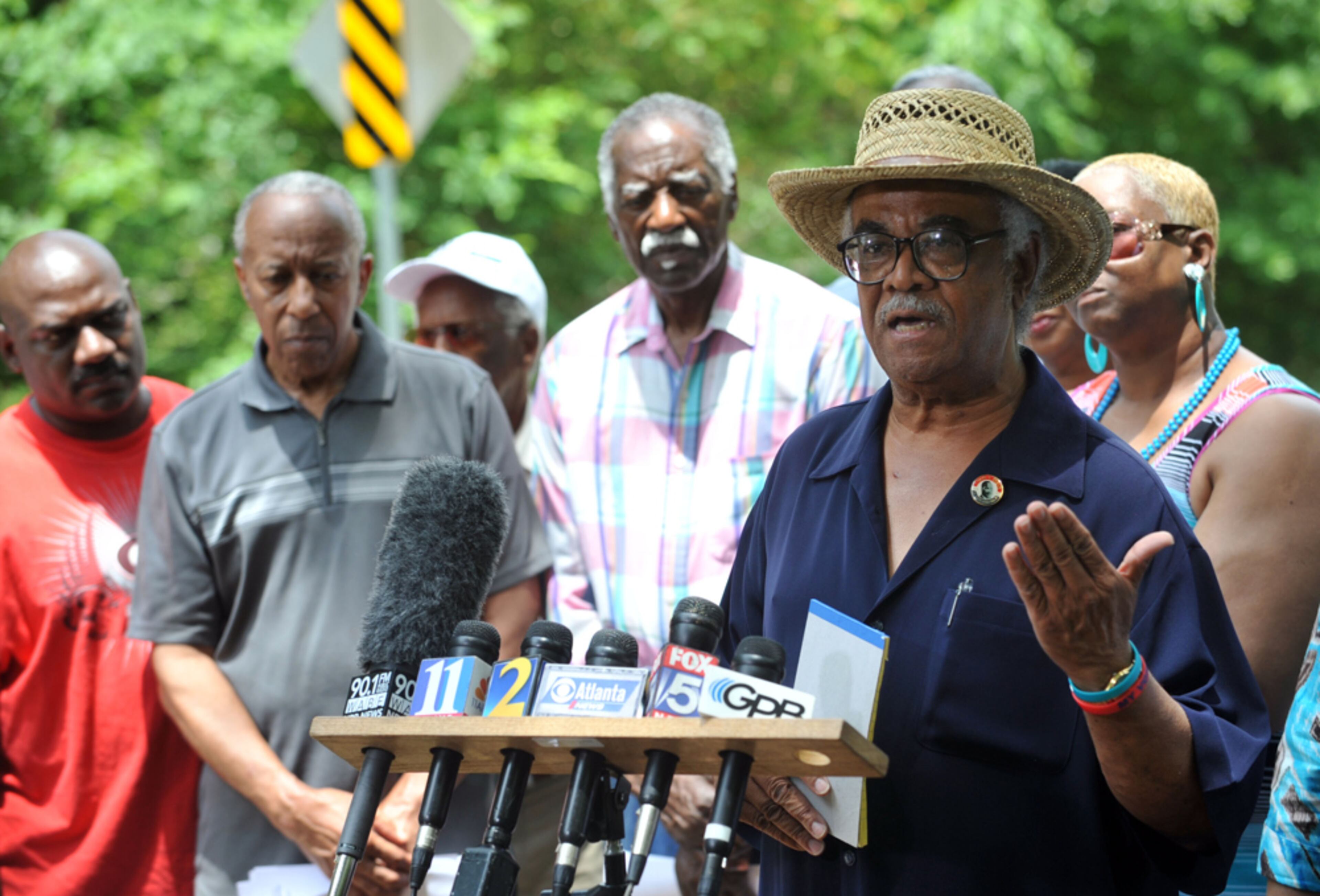 Supporters of Rep. Tyrone Brooks, D-Atlanta, listen as he holds a press conference at the Moore's Ford Bridge Thursday, May 30, 2013. When Brooks was hit earlier that month with a 30-count indictment accusing him of mail, wire and tax fraud, he said the FBI was trying to silence his claims that the Moore's Ford murders could never have happened or been covered up without the “active participation of law enforcement.” Brooks has said he believes FBI agents at the time were involved. Neither the FBI nor the U.S. Attorney’s office would discuss Brooks’ accusations.