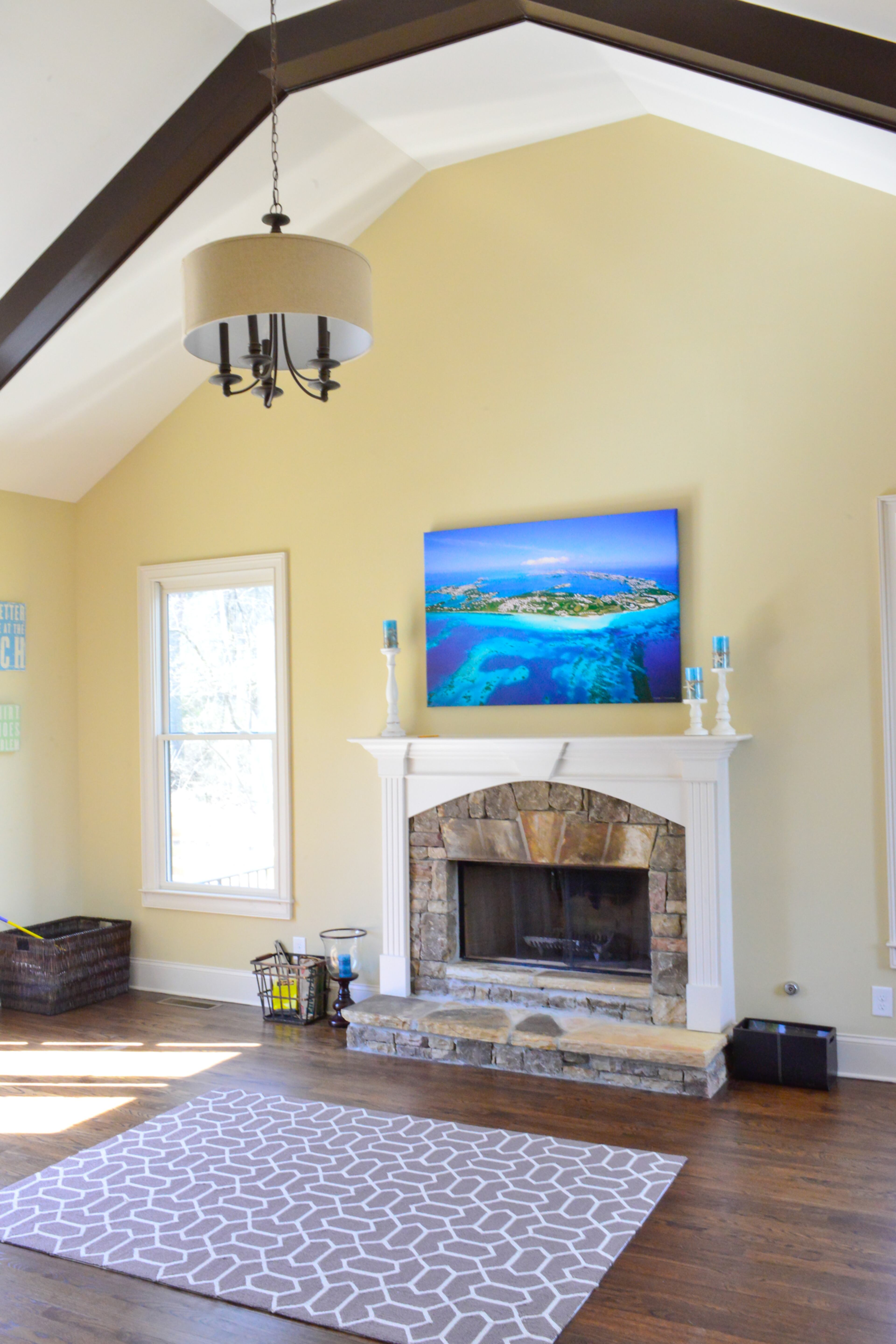 The kitchen connects to a keeping room, which features a fireplace with a stone surround and exposed beams on the vaulted ceiling. Homeowners Justin and Sophia DeCouto are from Bermuda, which is featured in a large photo - taken by a photographer in Bermuda -- of the island that hangs over the fireplace.