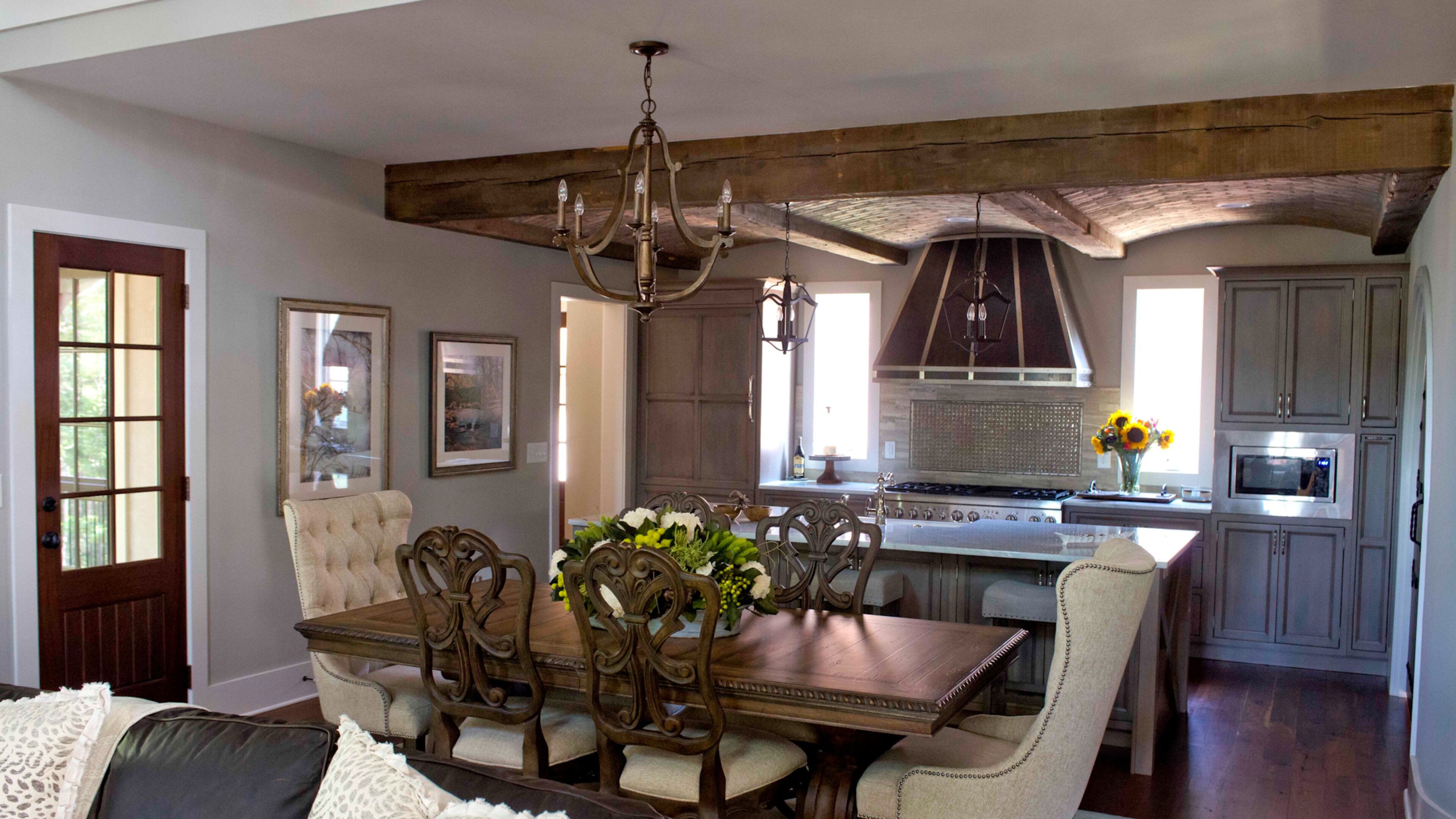 The kitchen, which opens to the dining room and great room, is tied together with the use of wood beams and arches. Custom elements include work by CWP Cabinetry and The Metal Shoppe (vent hood). "It is a wonderful space to entertain," said Stacy Vevoda.
