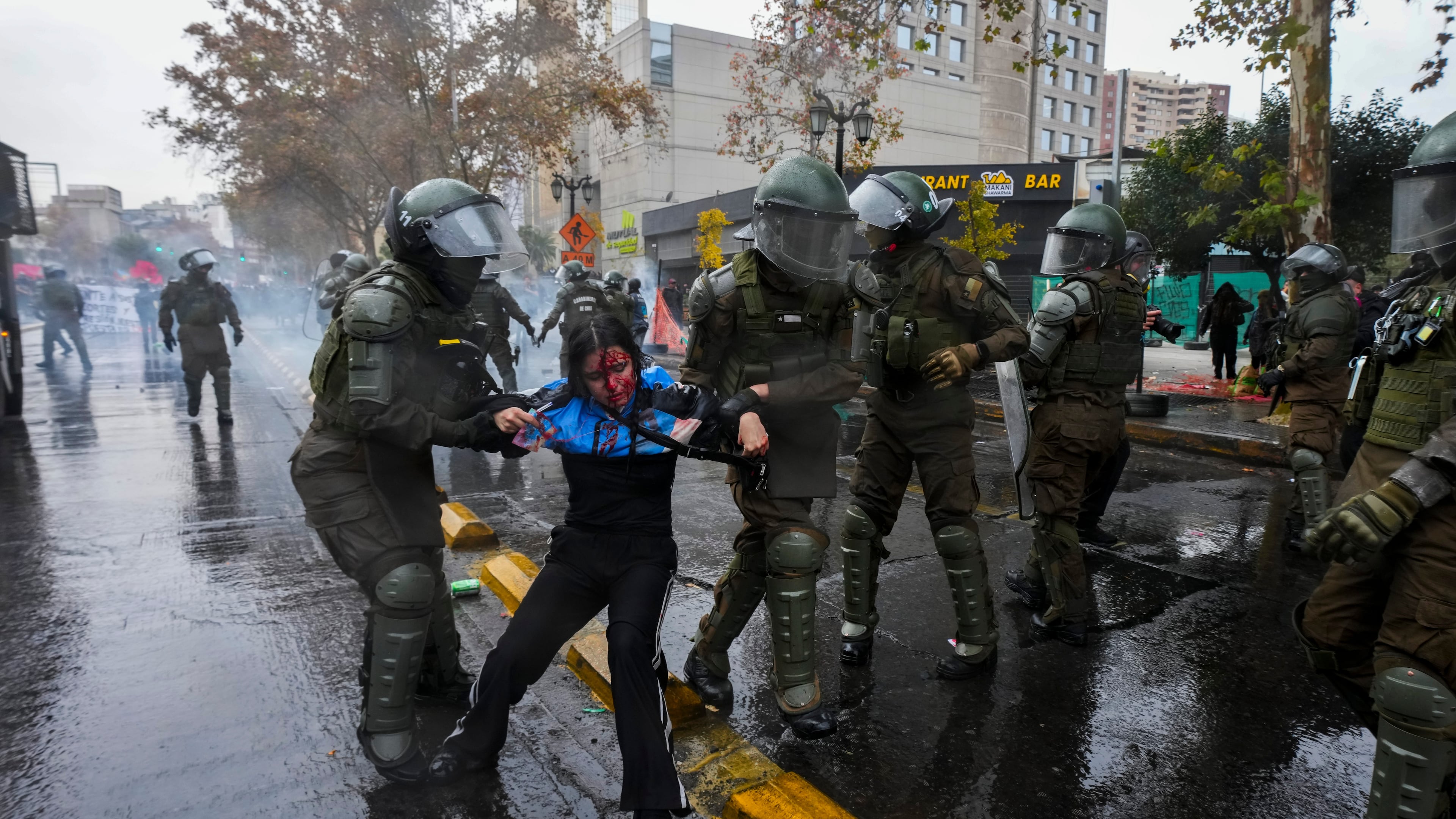 An injured student is detained by police during a protest against the government's proposal to lower the education budget, in Santiago, Chile, Wednesday, June 3, 2026. (AP Photo/Esteban Felix)