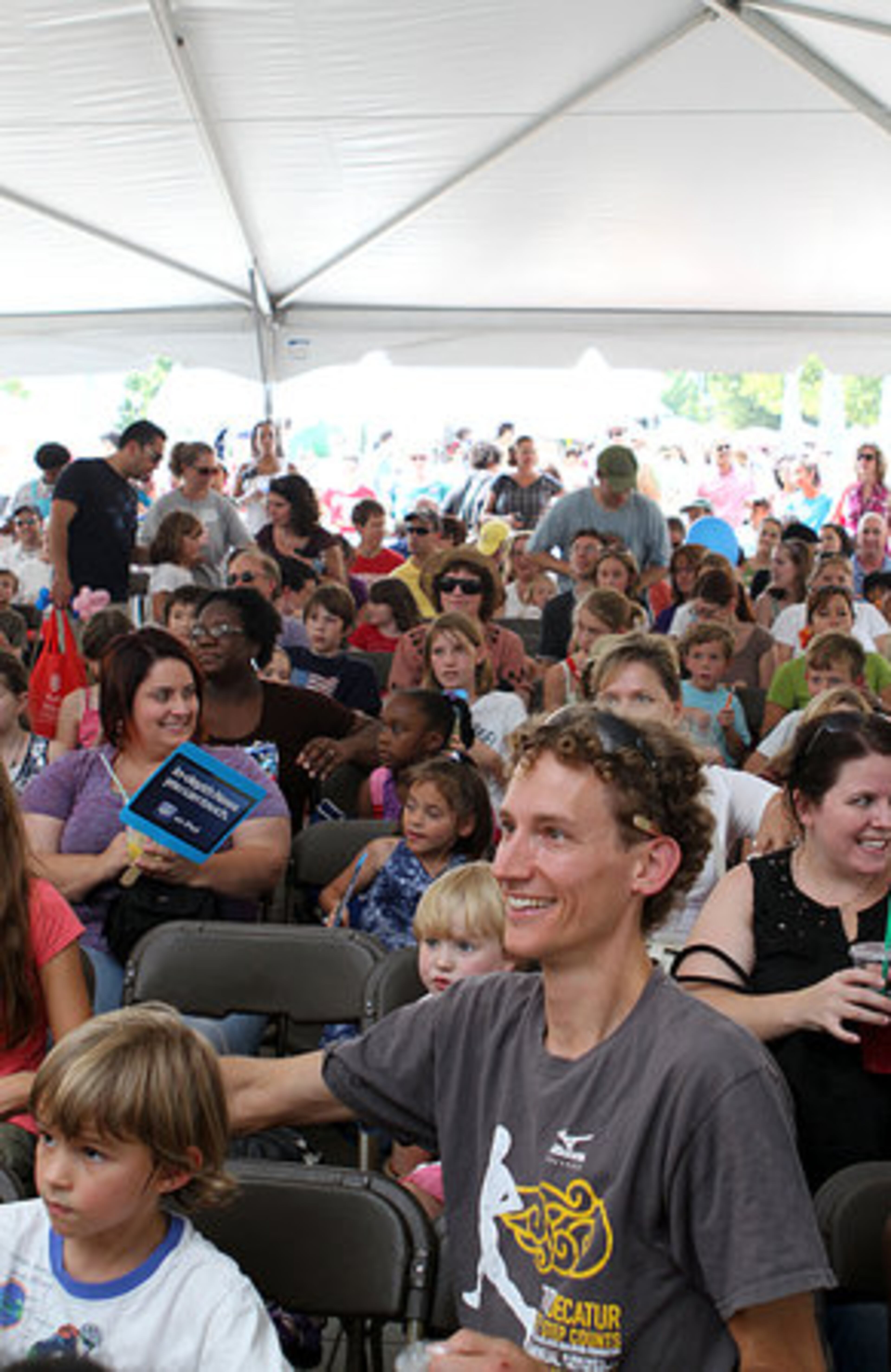 Christopher Weiser (right) is among the crowd gathered under a tent at the Children's Stage during the annual AJC Decatur Book Festival in downtown Decatur on Saturday, Sept. 3, 2011.