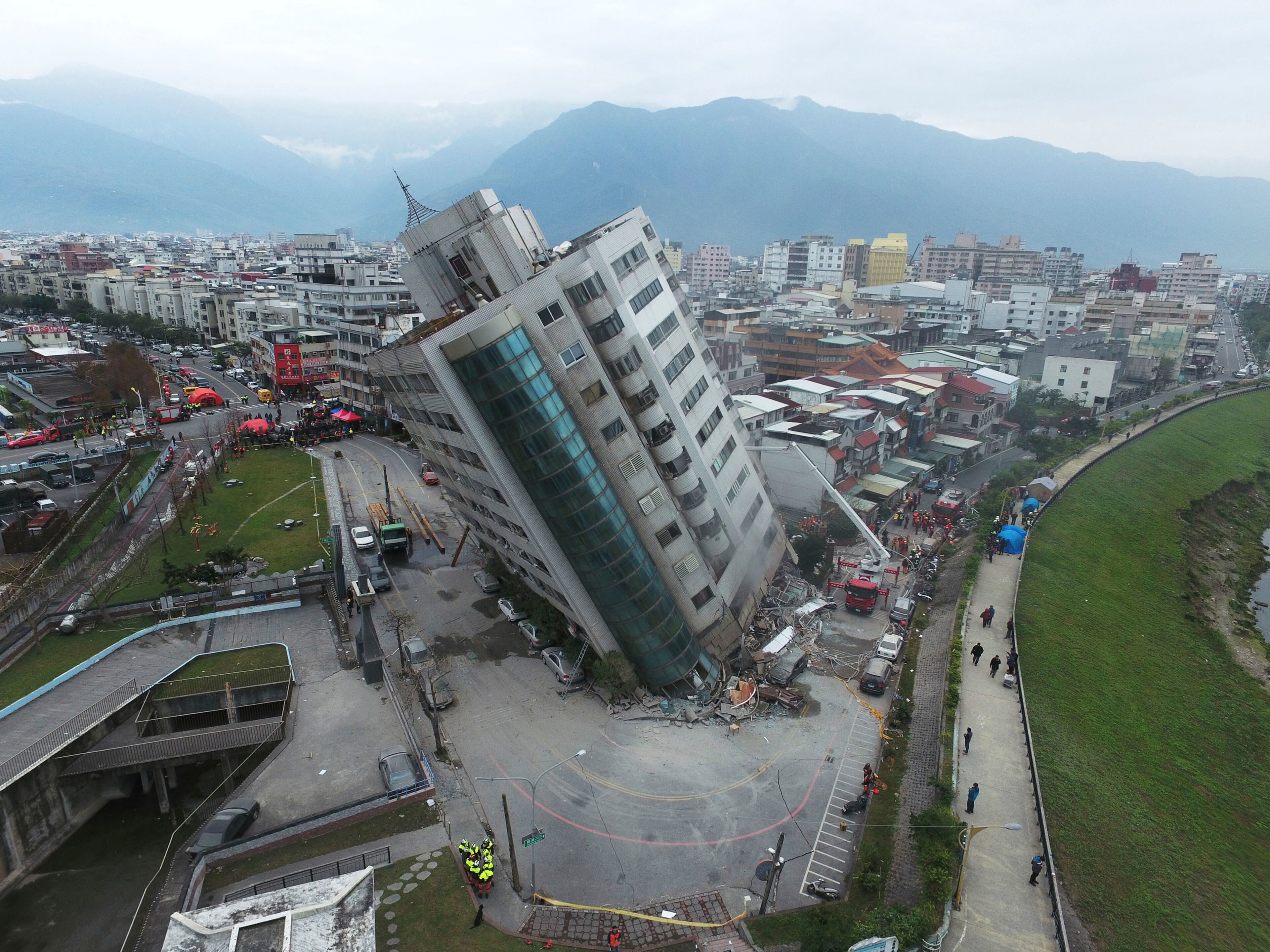 A residential building leans on a collapsed first floor following an earthquake, Wednesday, Feb. 7, 2018, in Hualien, southern Taiwan. Rescue crews continue to try free people from damaged buildings after a strong earthquake hit near Taiwan's east coast and killed at least four people. (Central News Agency via AP)