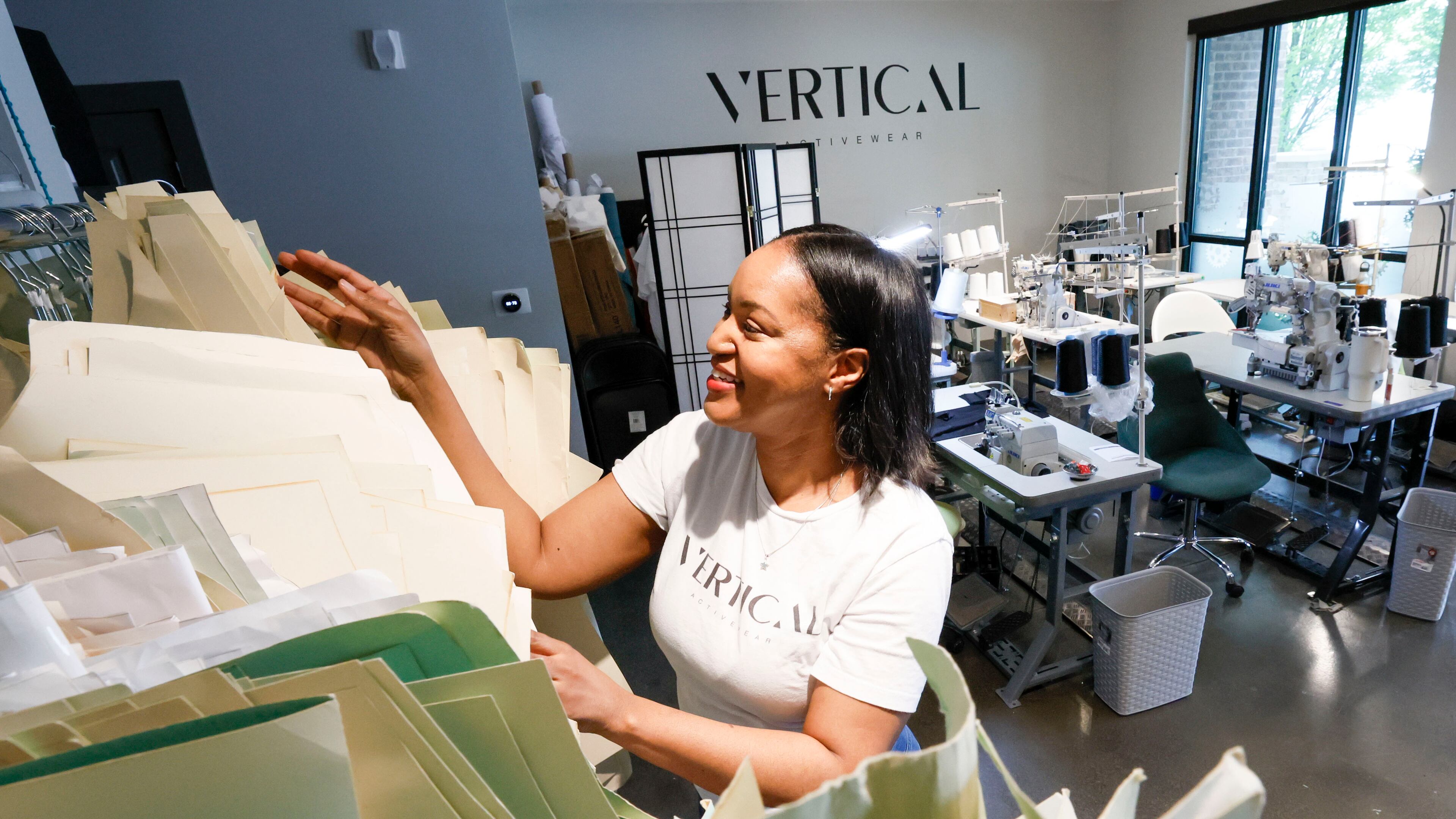 Tia Robinson, founder and CEO of Vertical Activewear, selects patterns to use for producing activewear clothing at her studio in Duluth. Robinson’s business may benefit from tariffs since all the fabrics and materials used are sourced from manufacturers within the United States.
(Miguel Martinez/ AJC)