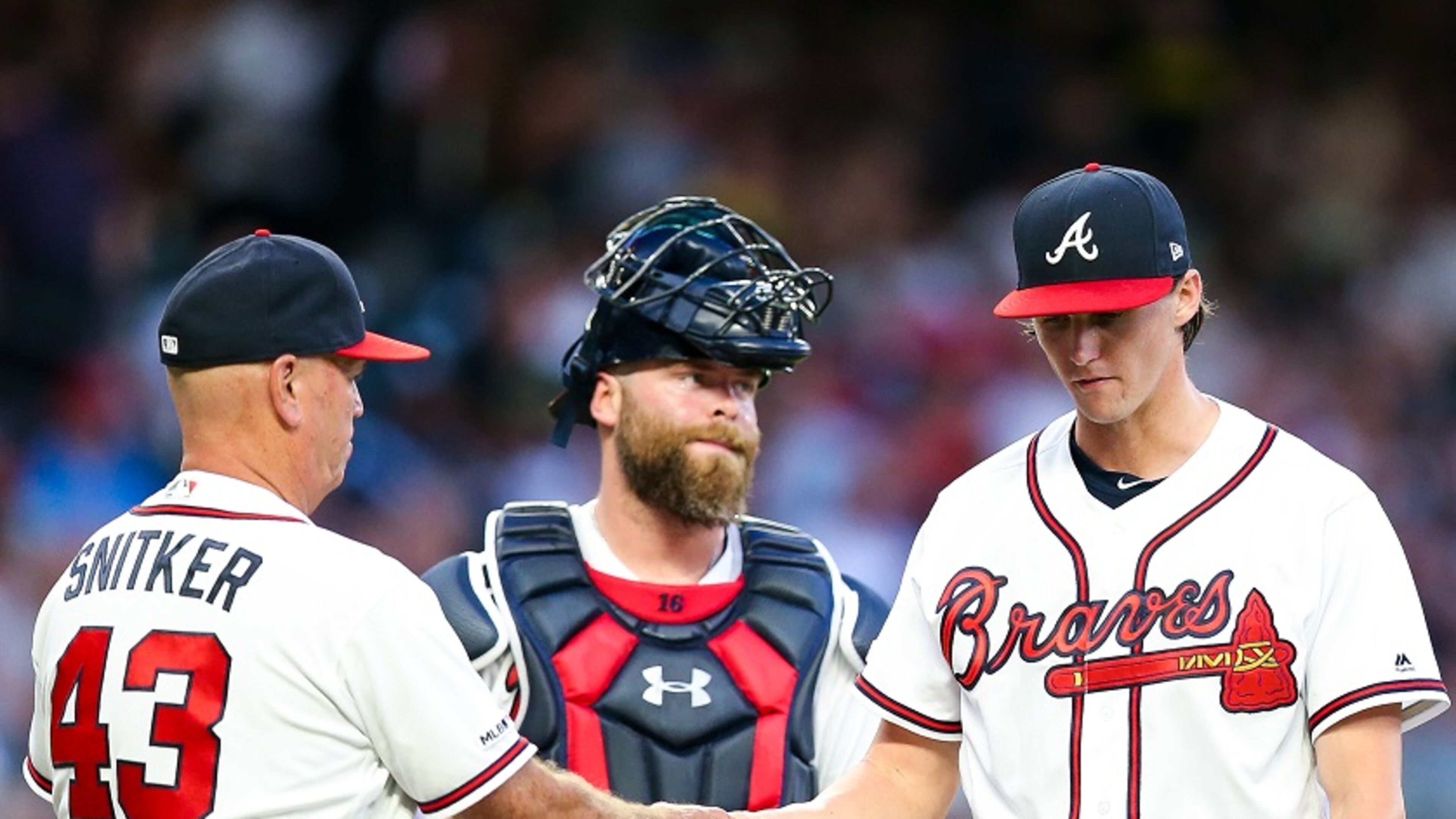 Kyle Wright (right) hands the ball to manager Brian Snitker after he’s pulled from the game. (Photo by Carmen Mandato/Getty Images)