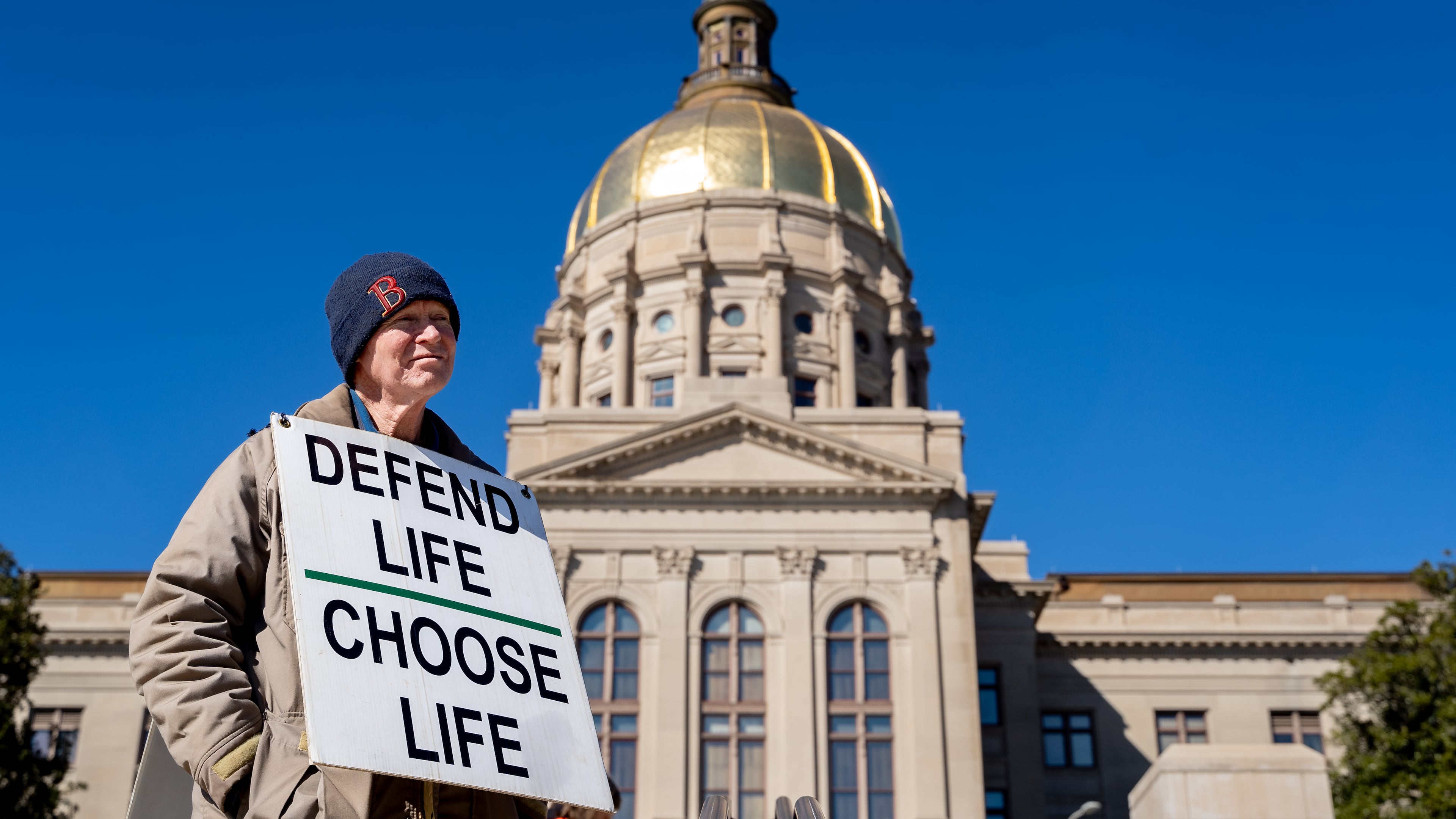 Jack Harvey holds a sign that reads “Defend life, choose life” during a silent march in the streets of downtown Atlanta to commemorate the anniversary of the 1973 Supreme Court ruling in Roe v. Wade on Friday, Jan. 24, 2025. (Ben Hendren for the AJC)