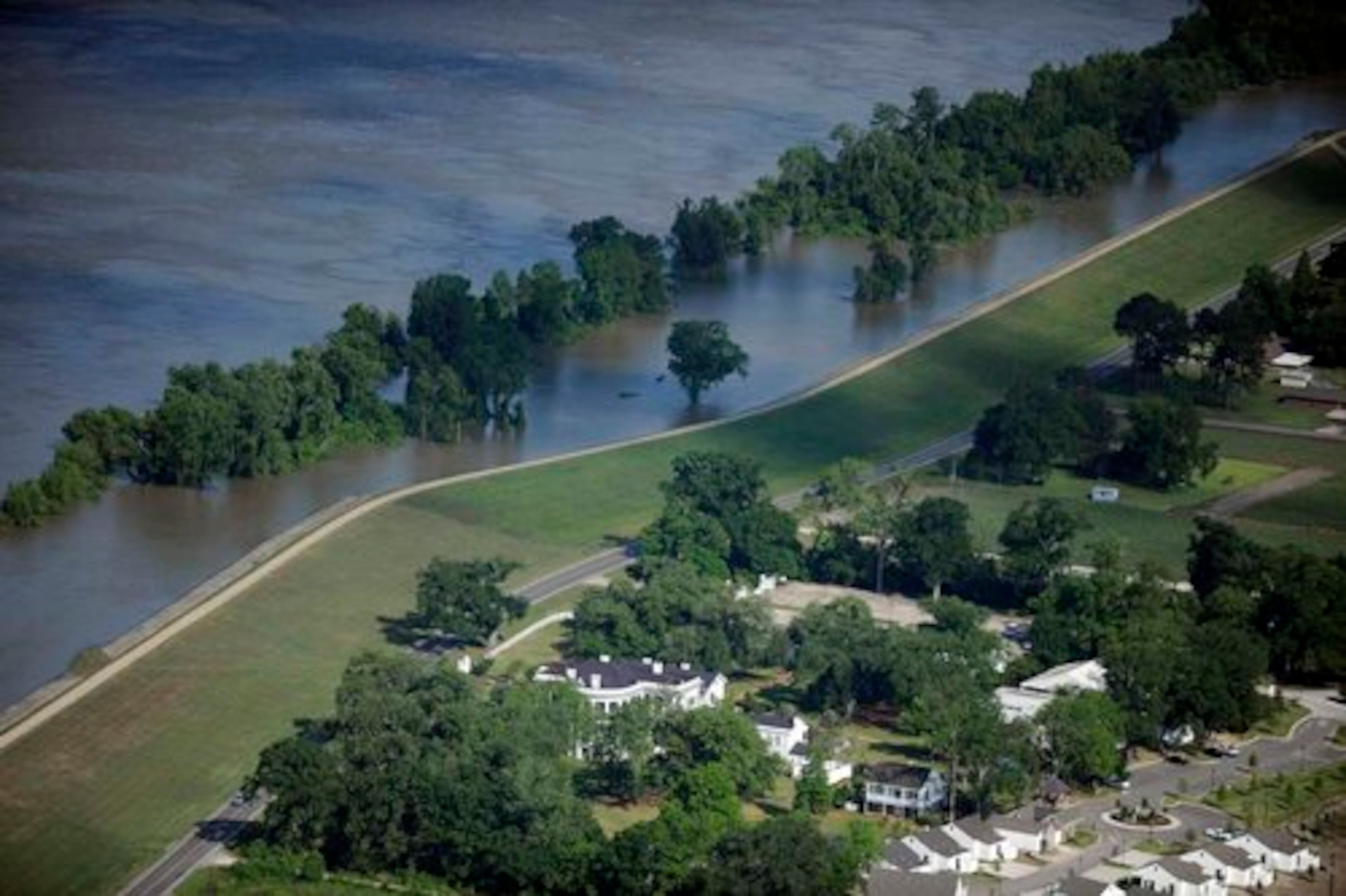 Rising Mississippi River waters, held back by a levee, slowly creep toward Nottoway Plantation in White Castle, La.