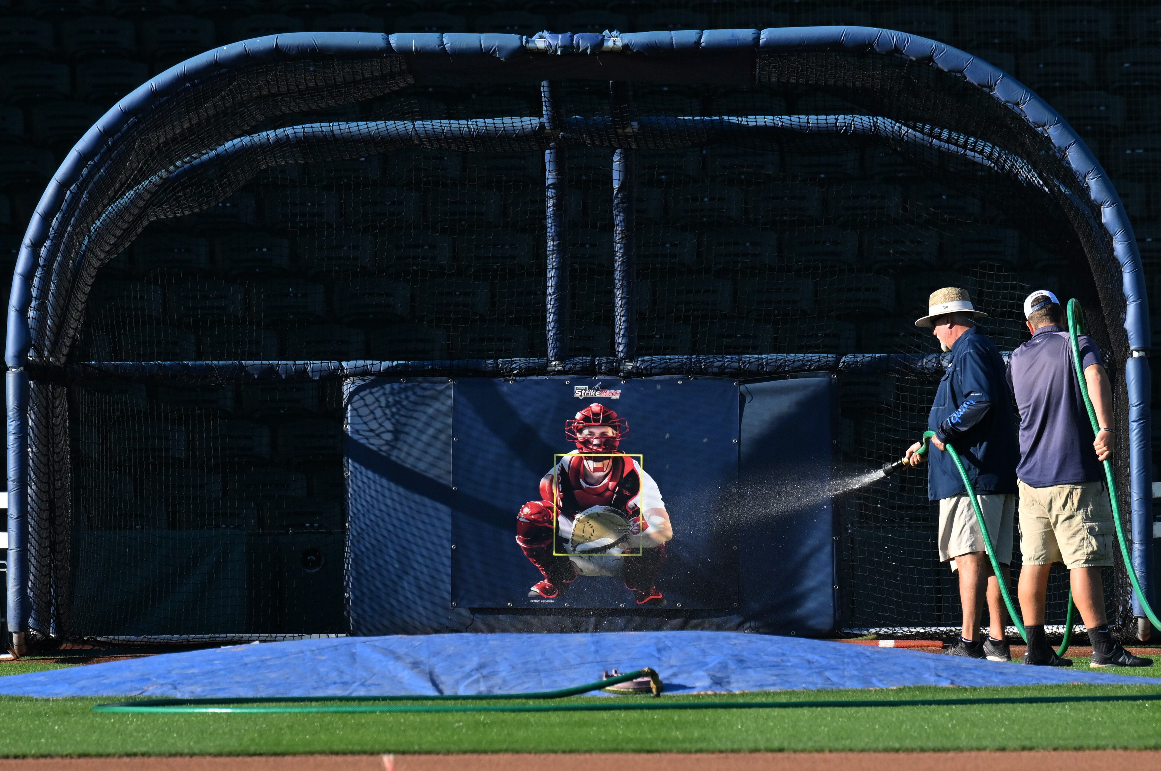 The grounds crew prepares a batting cage Wednesday during spring training at CoolToday Park in North Port, Florida. (Hyosub Shin / Hyosub.Shin@ajc.com)