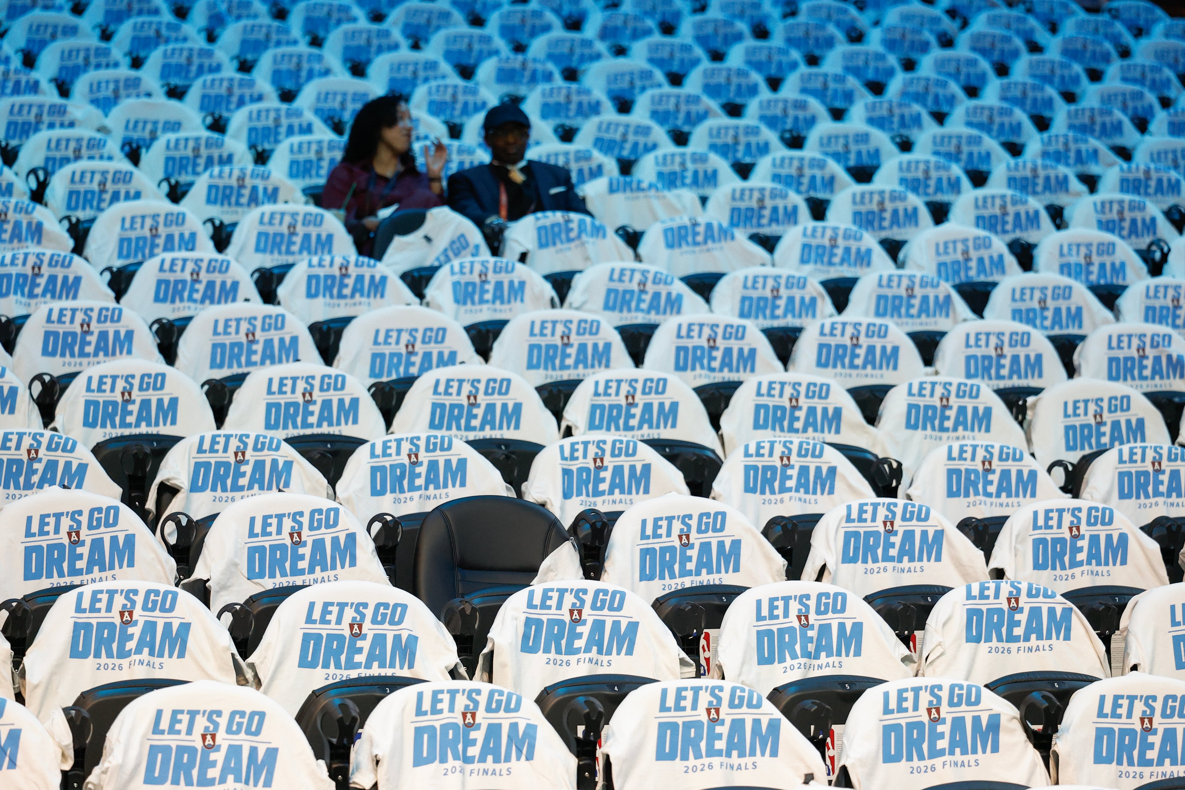 Two people watch teams warm up before Game 4 of the WNBA Finals between the Atlanta Dream and the Golden State Valkyries, Saturday, Oct. 24, 2026, in Atlanta. (Erik S. Lesser for the AJC)