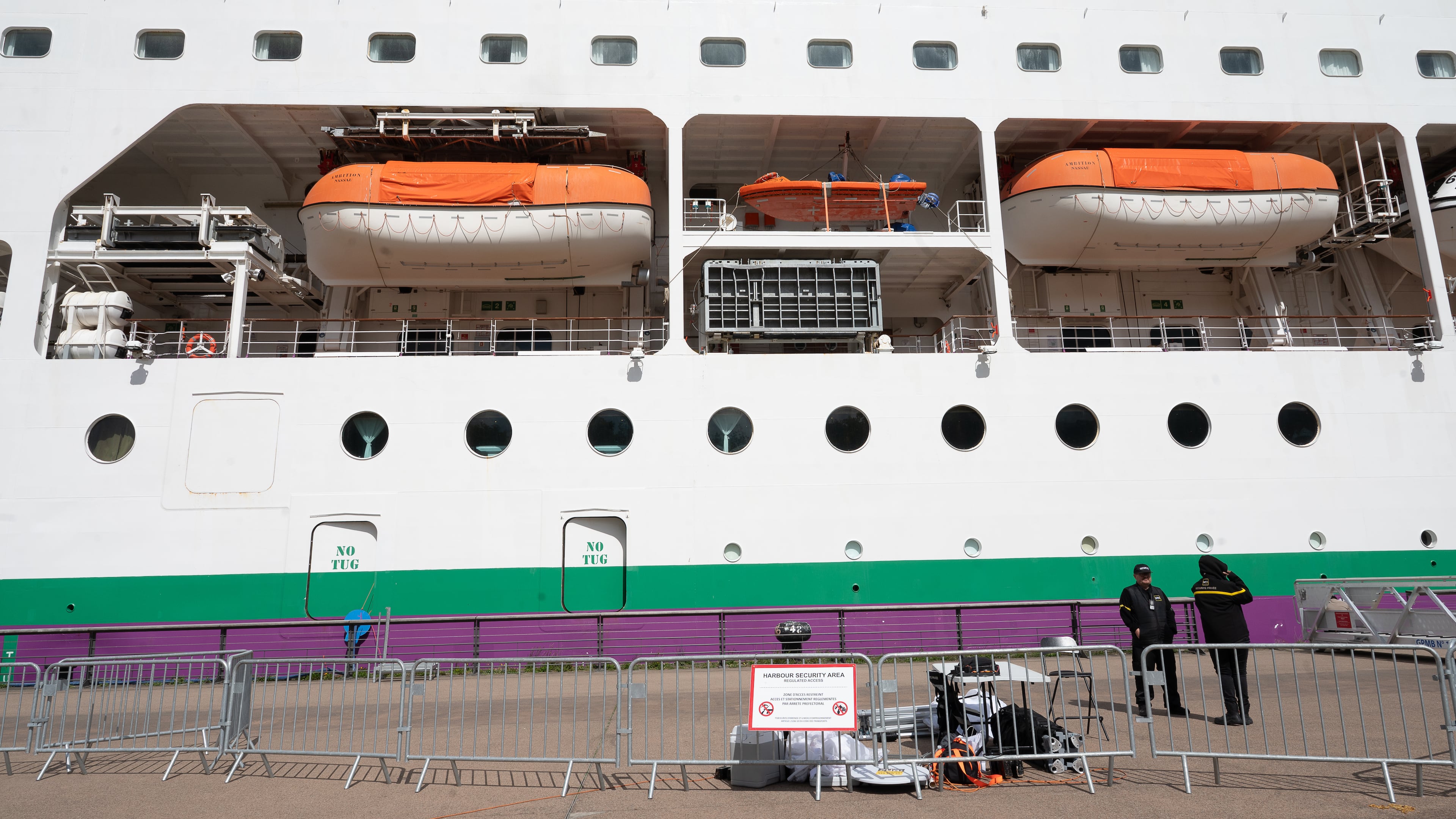 A barrier is set in front of the British cruise ship Ambition, as French authorities have ordered 1,700 passengers and crew to stay on board due to a gastrointestinal illness outbreak, in Bordeaux, southwestern France, Wednesday, May 13, 2026. (AP Photo/Caroline Blumberg)