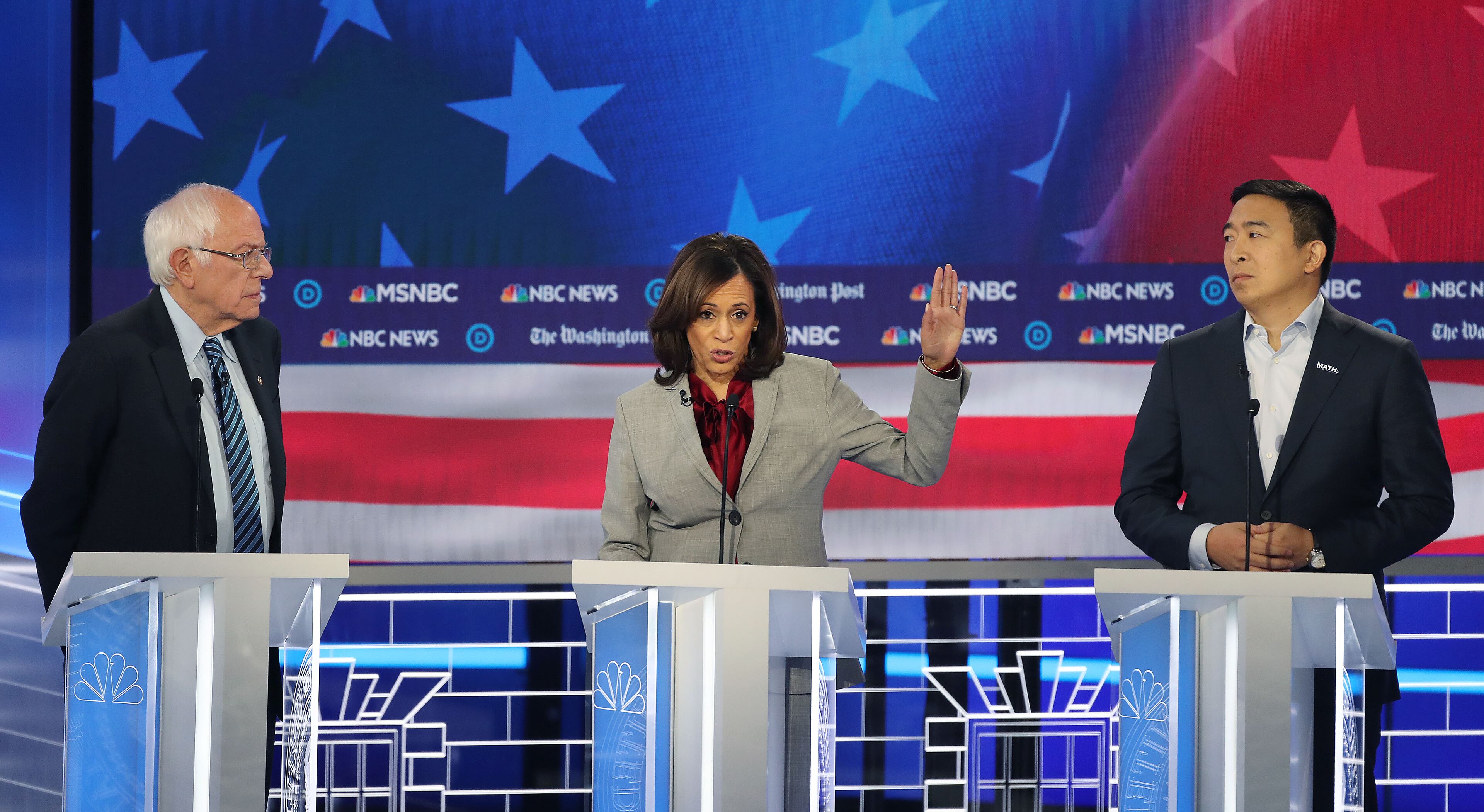 11/20/2019 -- Atlanta, Georgia -- Senator Kamala Harris (center) speaks as Senator Bernie Sanders (left) and Andrew Yang look on, during the MSNBC/The Washington Post Democratic Presidential debate inside the Oprah Winfrey Soundstage at Tyler Perry Studios, Monday, November 20, 2019. (Alyssa Pointer/Atlanta Journal Constitution)