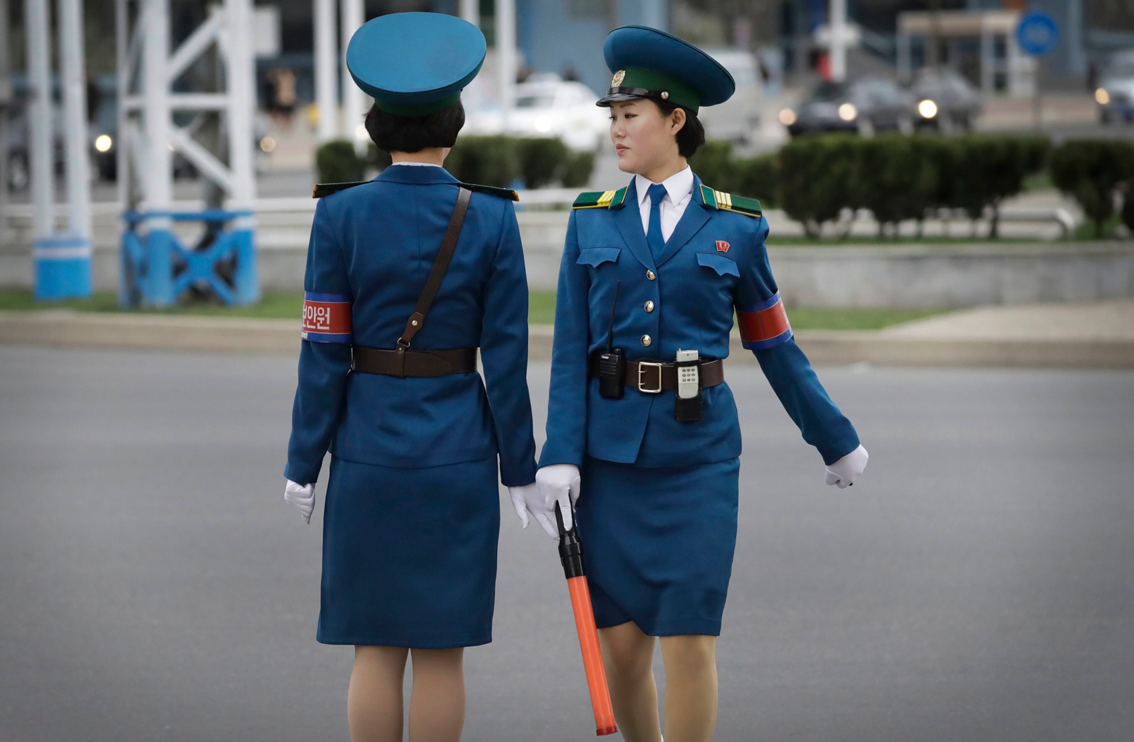 A North Korean traffic police woman hands over her LED wand used to guide traffic, over to her colleague as they prepare to change shifts on Wednesday, April 19, 2017, in Pyongyang, North Korea. (AP Photo/Wong Maye-E)