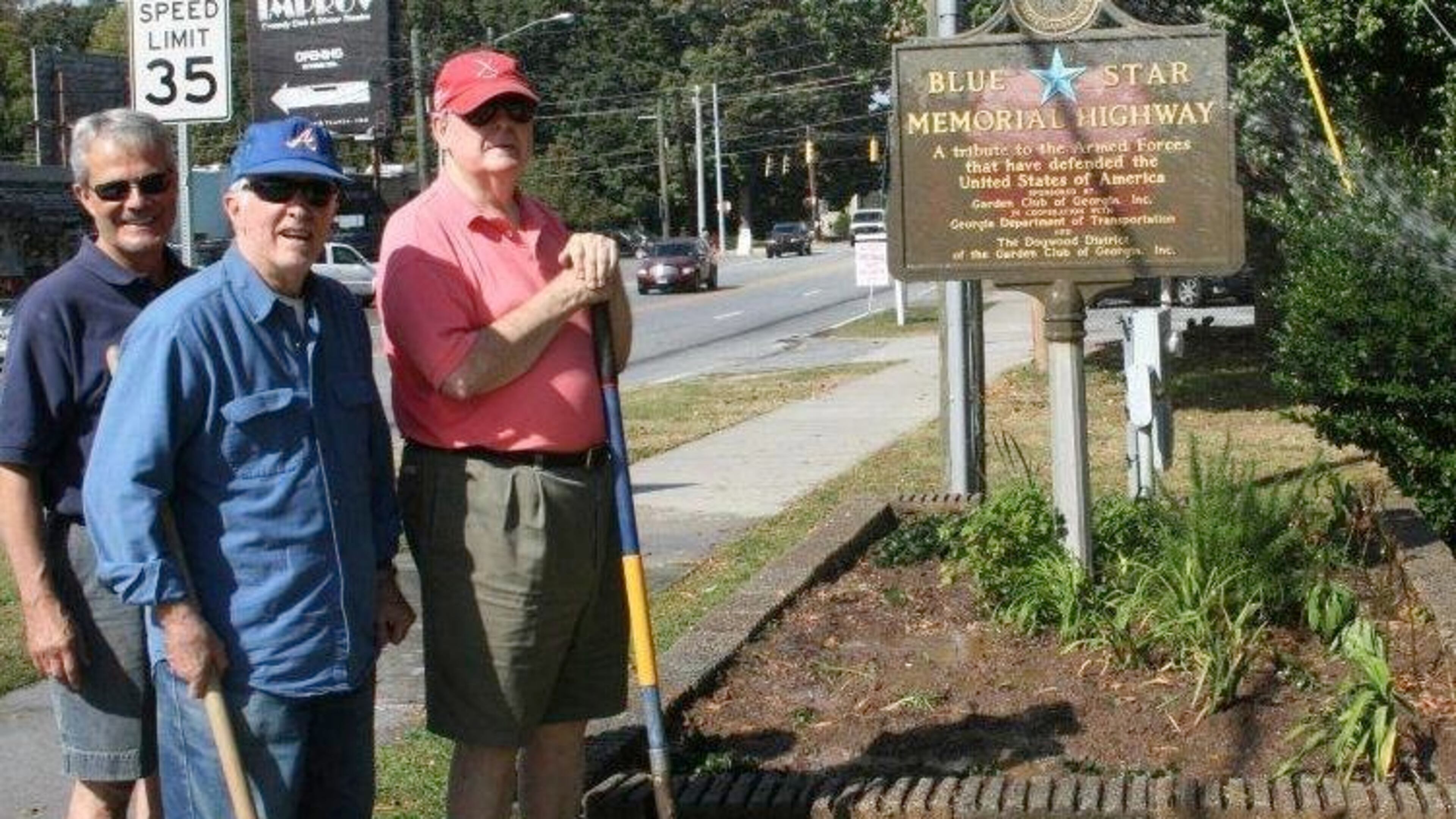Buckhead Men’s Garden Club members Allen Ferrell, Earl Masters and Rowland Hawthorne work at the marker in front of the Atlanta fire station on Roswell Road in 2013. The Buckhead Men’s Garden Club, which recently disbanded, planted the garden as a part of its beautification efforts. CONTRIBUTED